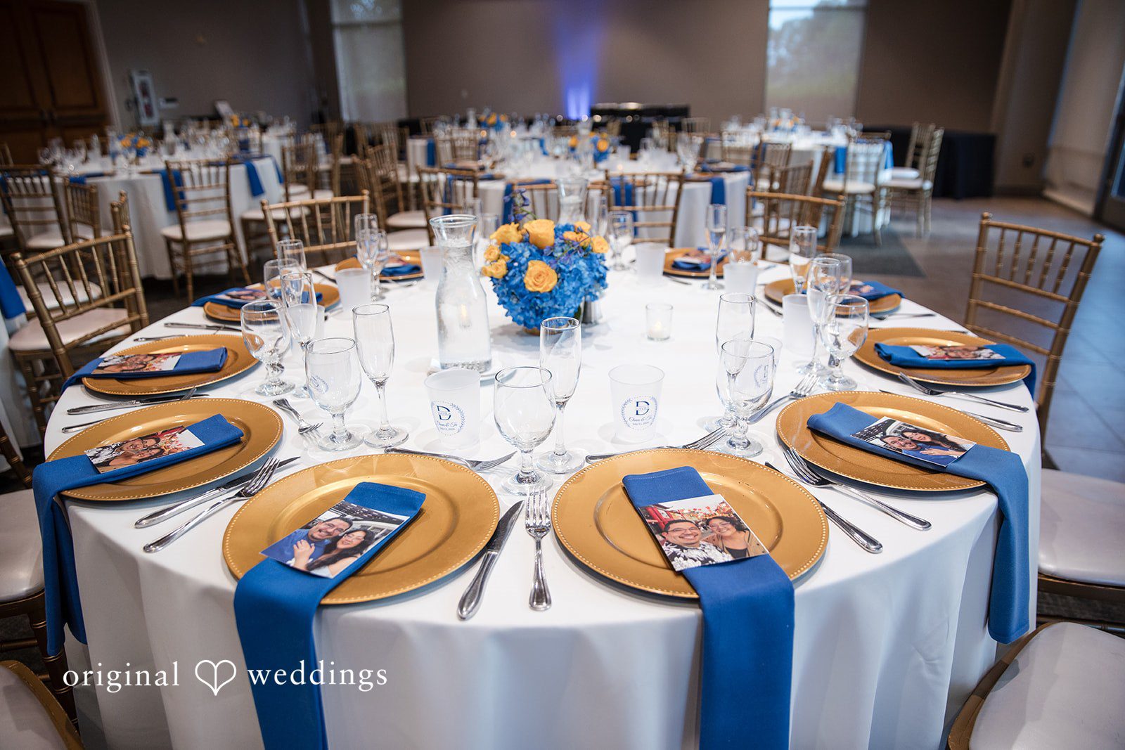 A round reception table set with blue napkins.