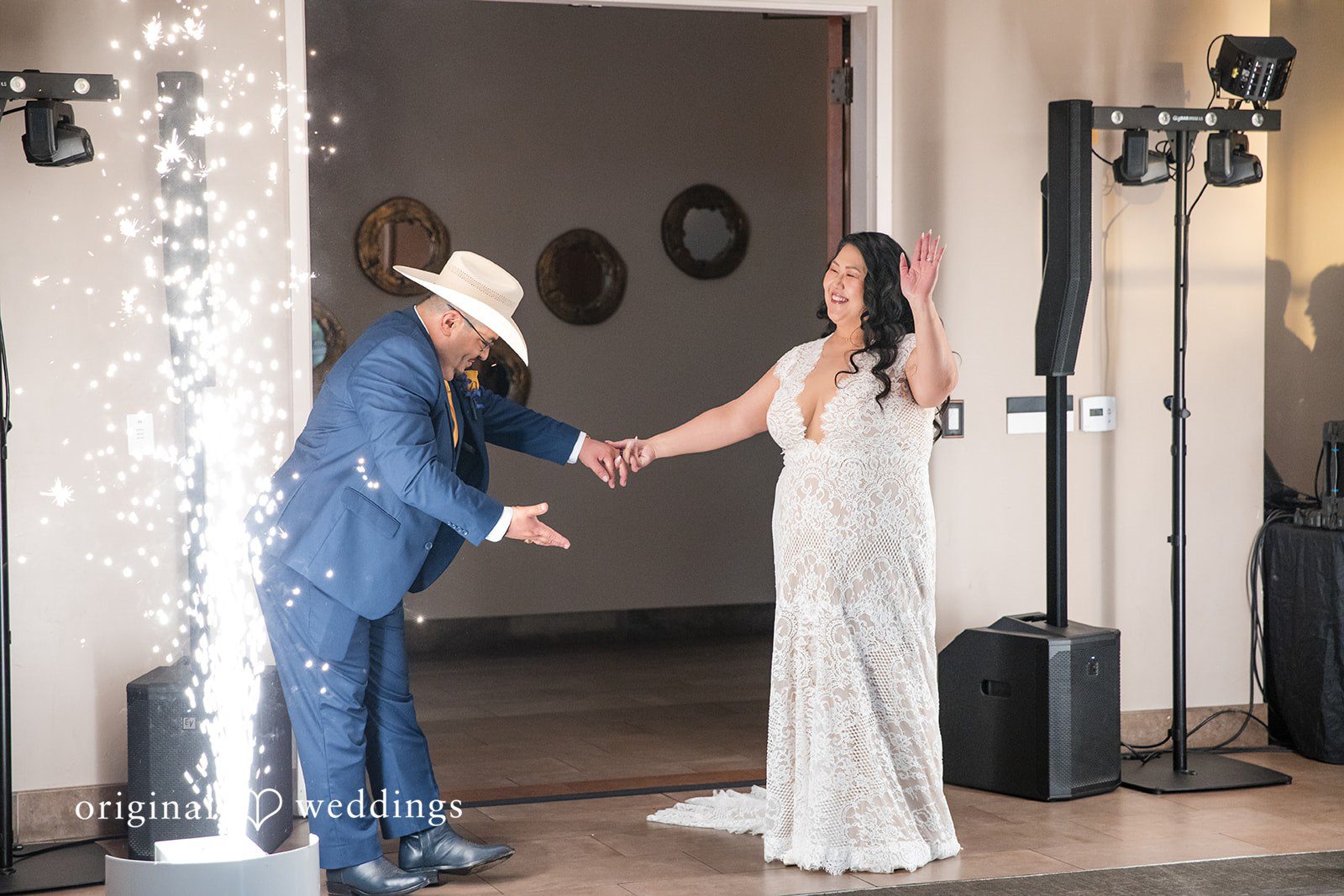 A bride and groom making their grand entrance into a reception hall.