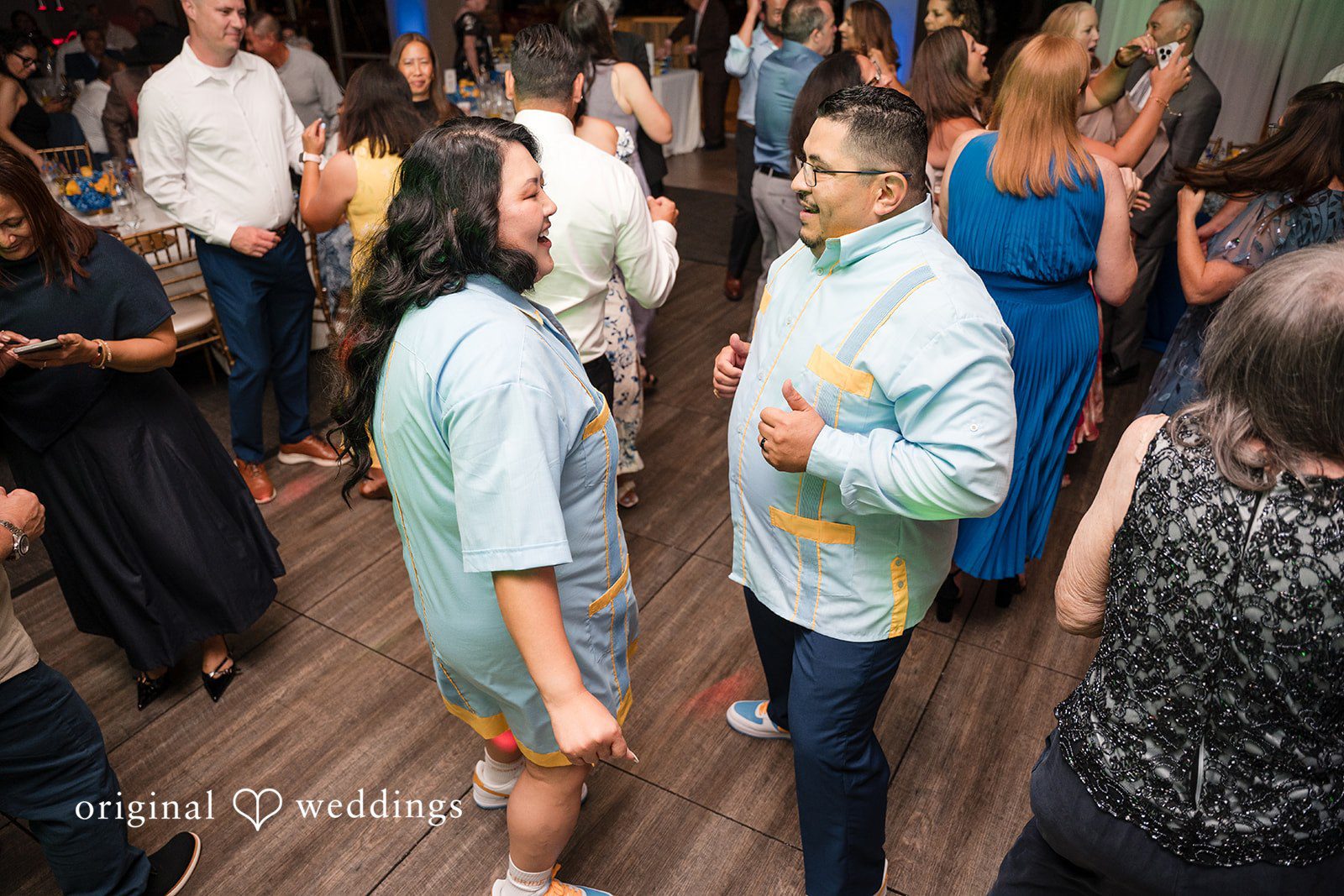 A group of wedding guests mingling and dancing together.
