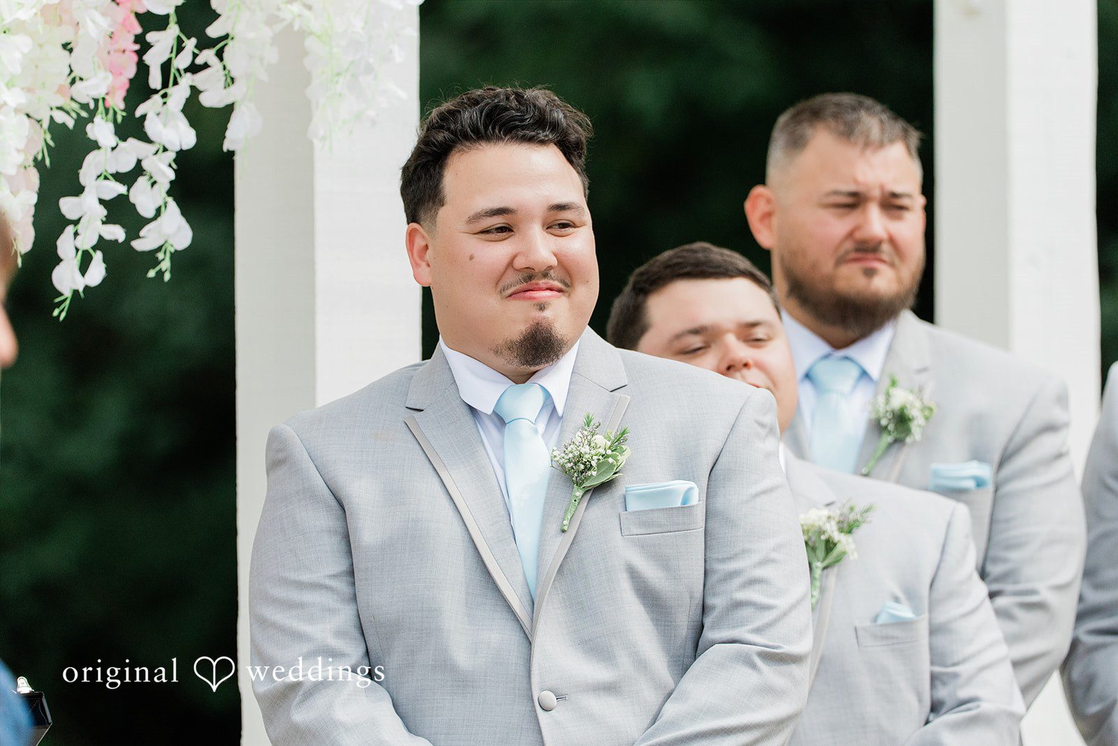 Alexander + Annalisse A groom and his groomsmen in light grey suits stand together for a wedding portrait.
