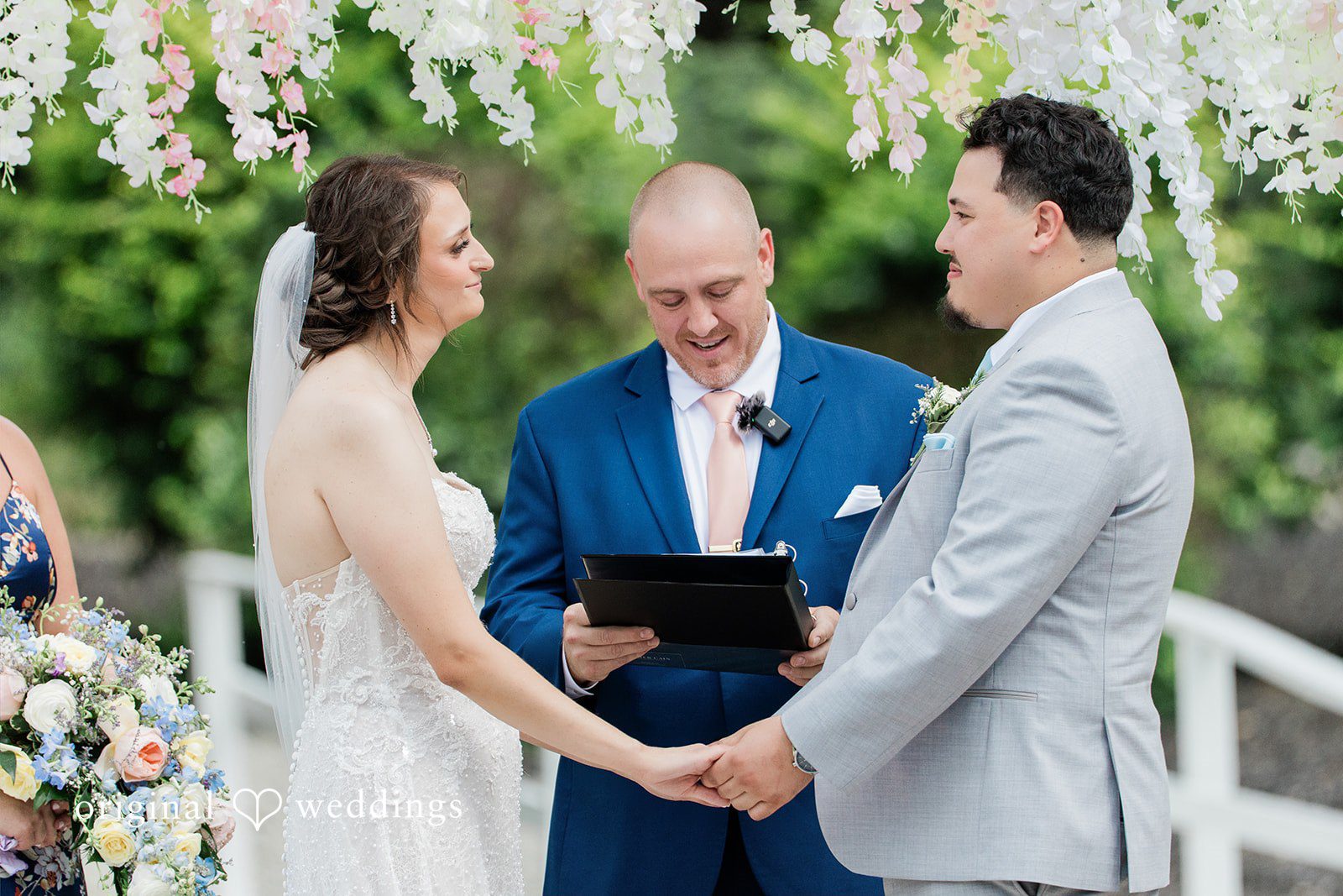 Alexander + Annalisse A wedding officiant guides the newlyweds through their vows at a beautifully decorated altar.