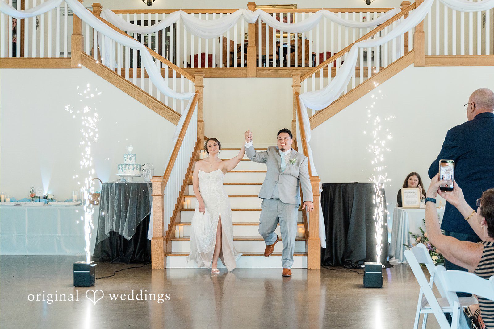 Alexander + Annalisse A wide shot shows the wedding party arranged along a dual staircase during a reception.