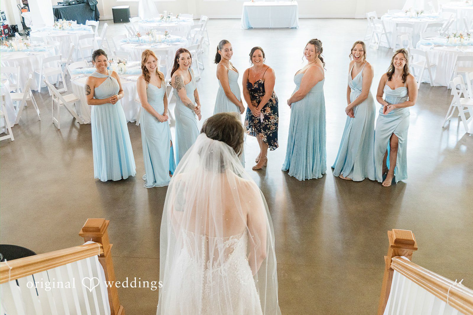 Alexander + Annalisse A bride in her veil stands before her bridal party dressed in light blue gowns.