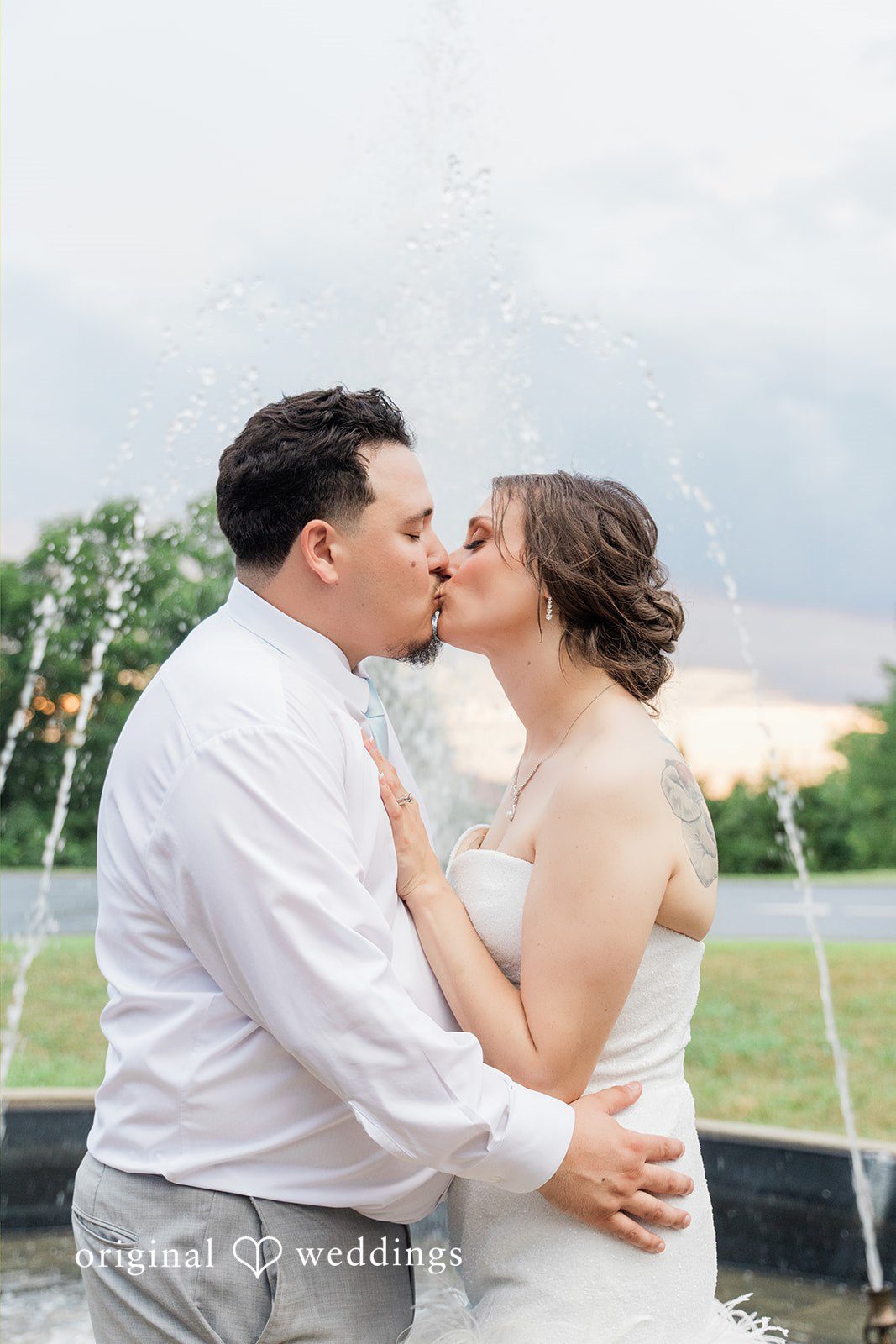 Alexander + Annalisse A groom in a white shirt holds his bride close as they share a candid, joyful moment.
