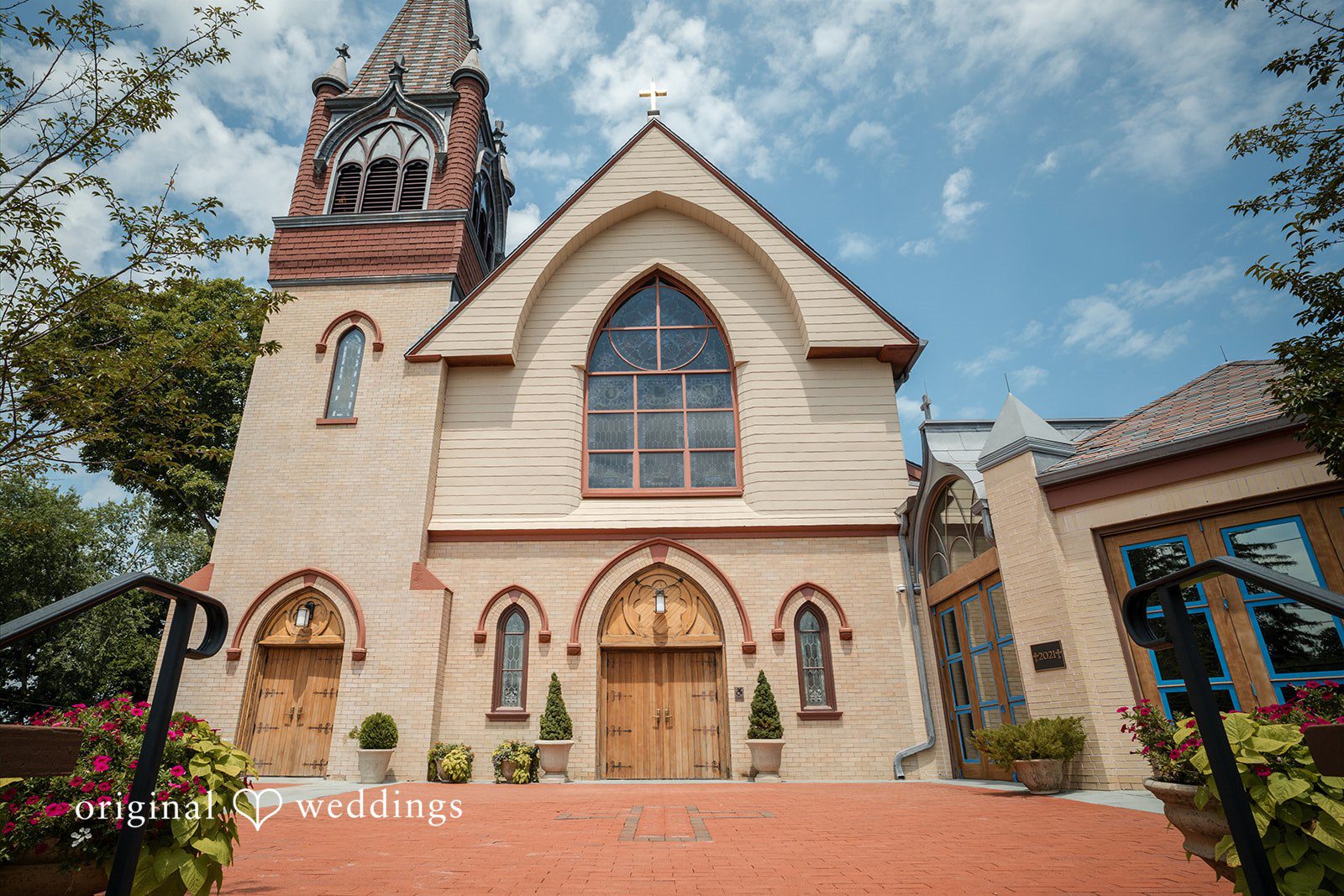 Nicole + Matt The stone exterior and entrance of a historic church under a clear blue sky.