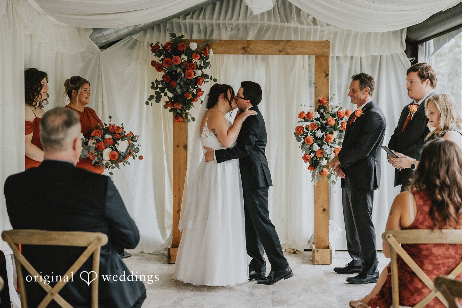 Bride and groom share first kiss after wedding ceremony.