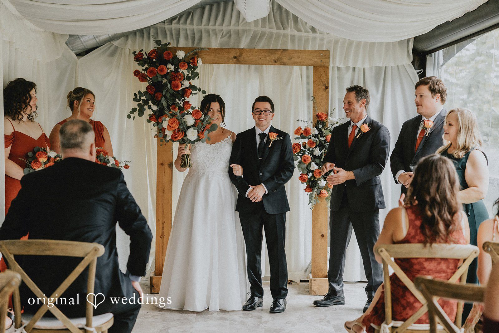 A wide view of a wedding ceremony in progress inside a decorated venue.