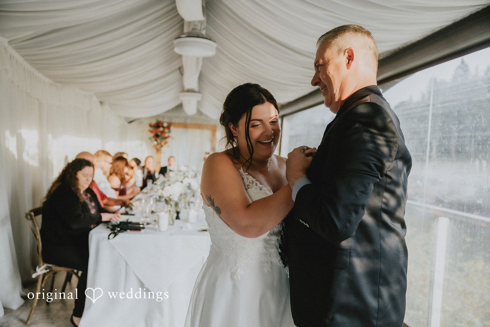 A bride and man standing together inside a building during their wedding reception.