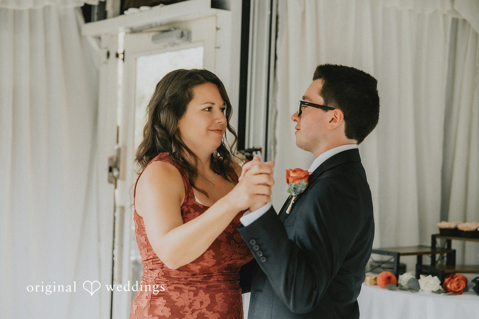 A man and woman smiling and raising a glass together during a celebration.