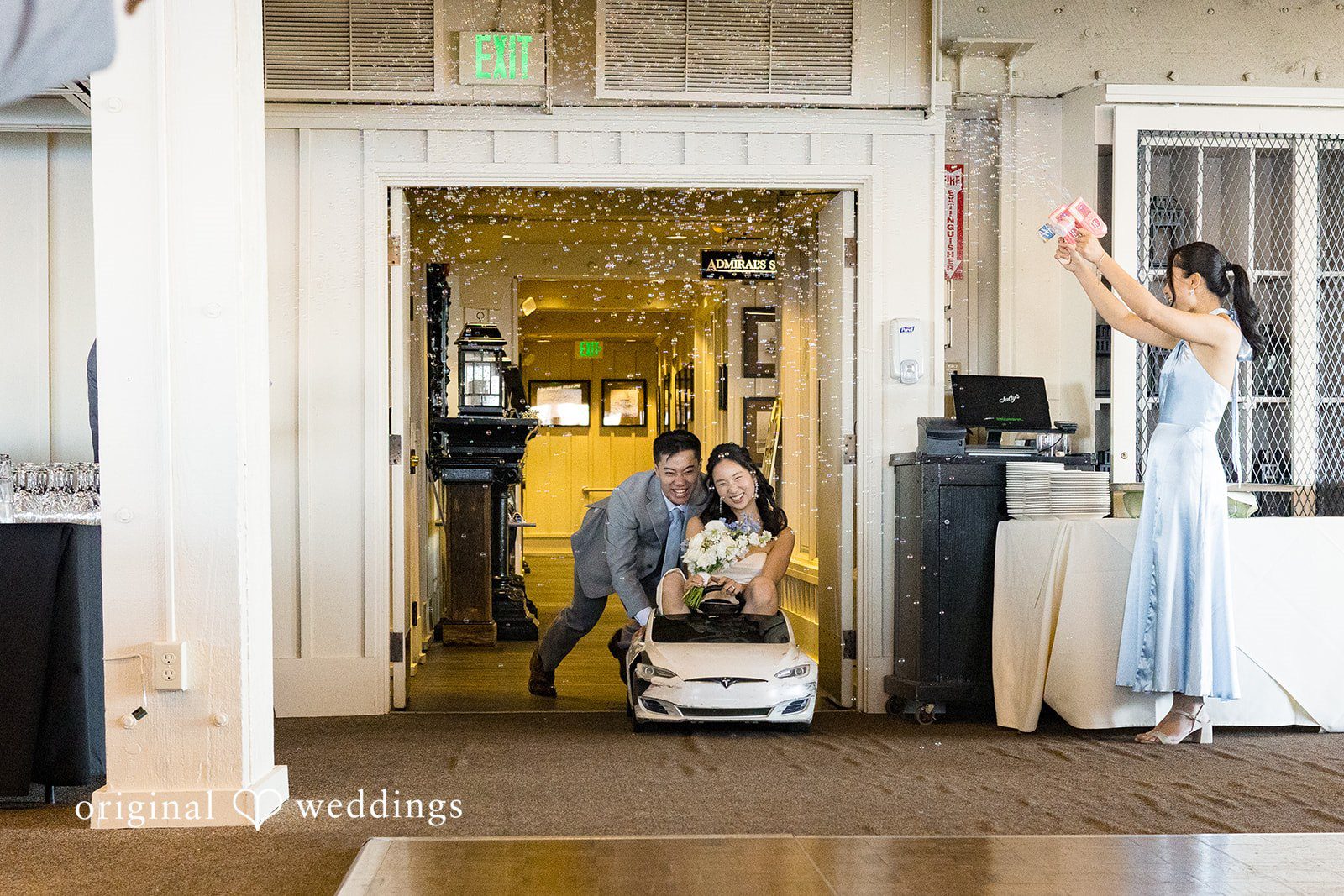 Emily + Paul A groom assisting his bride down an elevator or doorway inside a venue.