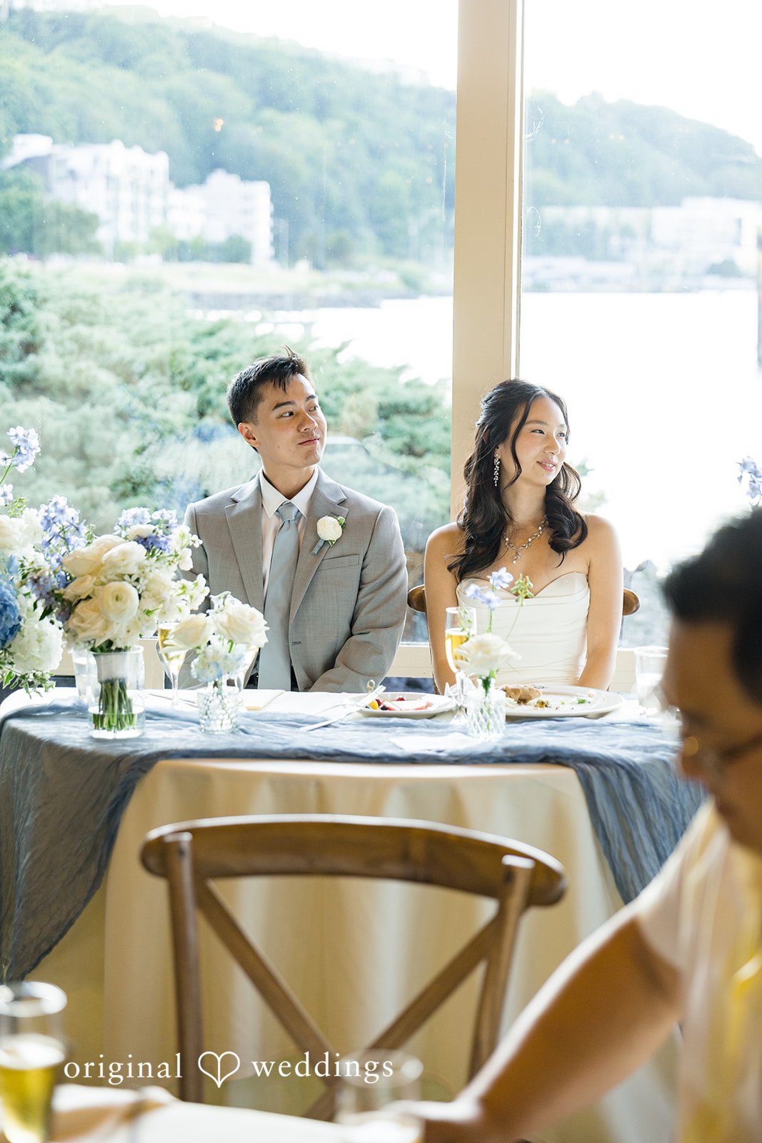 Emily + Paul A bride and groom sitting at their decorated reception sweetheart table.