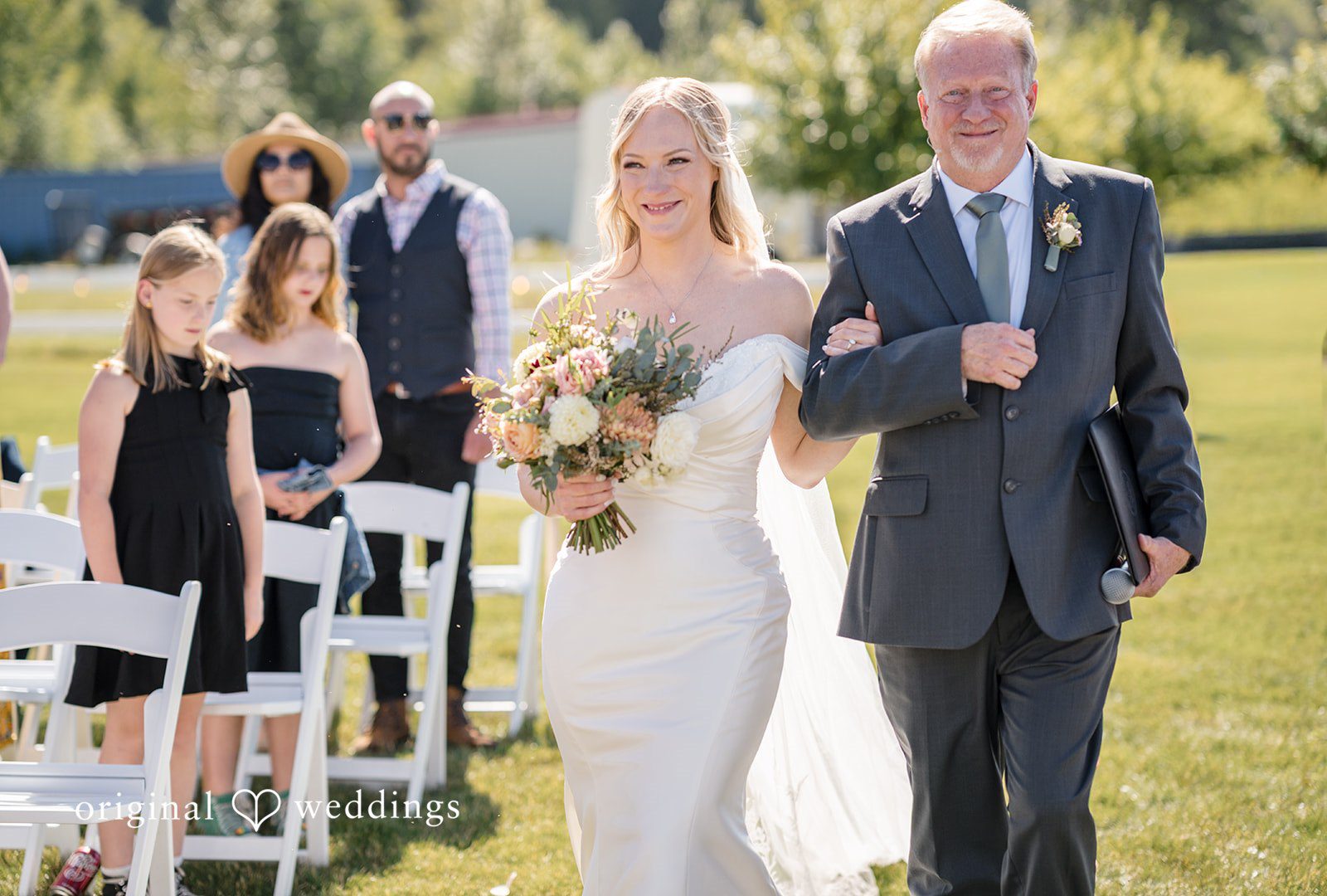 A bride and man walking down the aisle together.