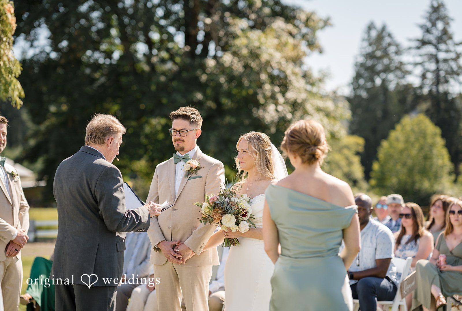 A wedding ceremony in progress with guests watching from behind the couple.