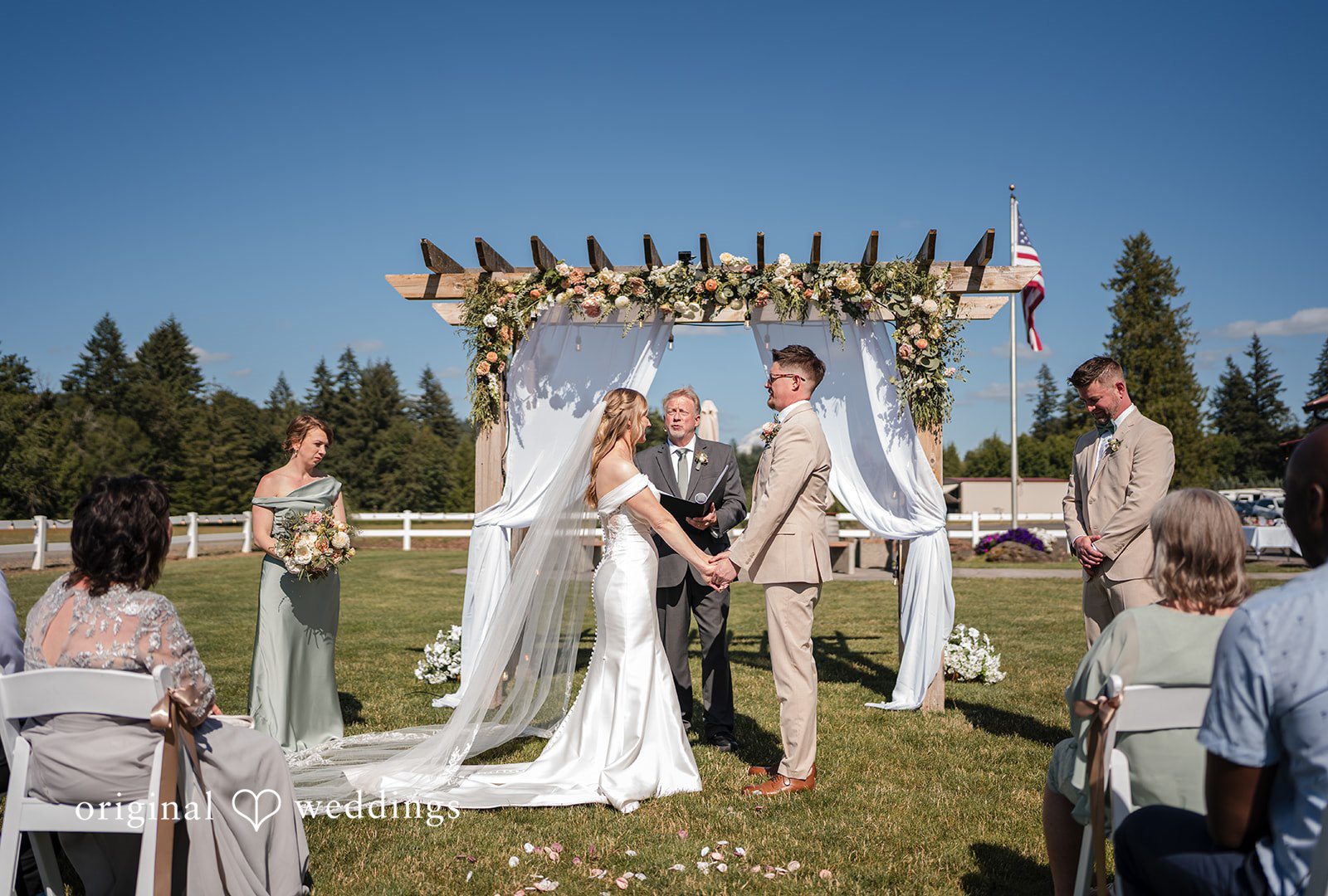 A wide view of an altar with a wedding ceremony taking place before seated guests.