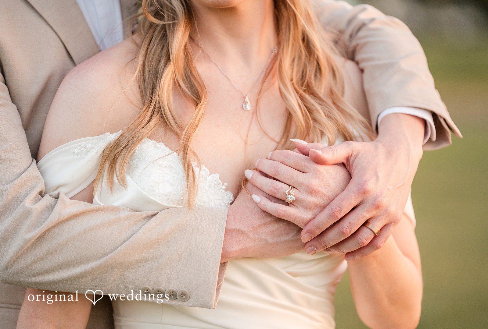A close-up view of a groom's hands wrapped and showing their rings.