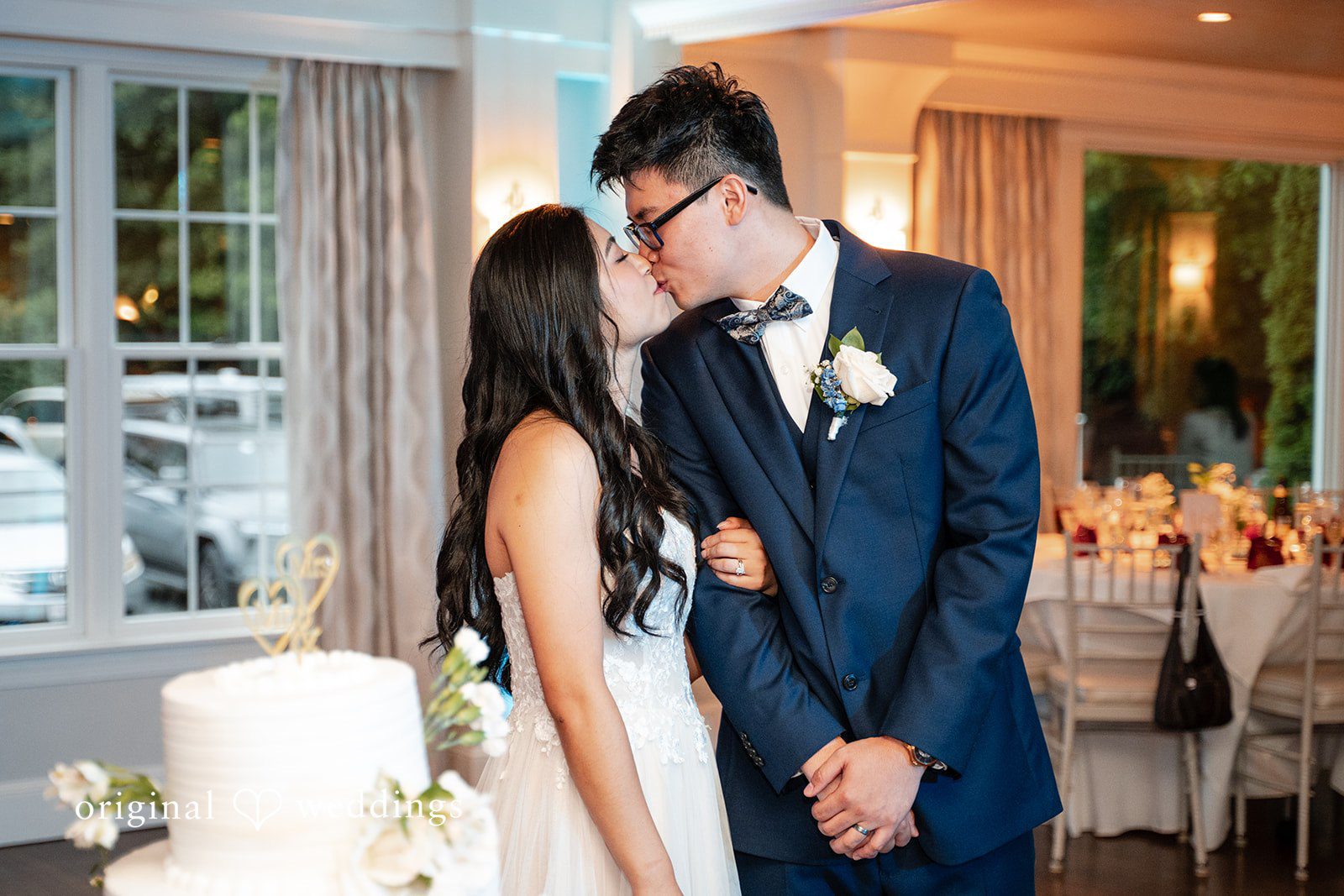 Bride and groom sharing a close moment together indoors near a window.