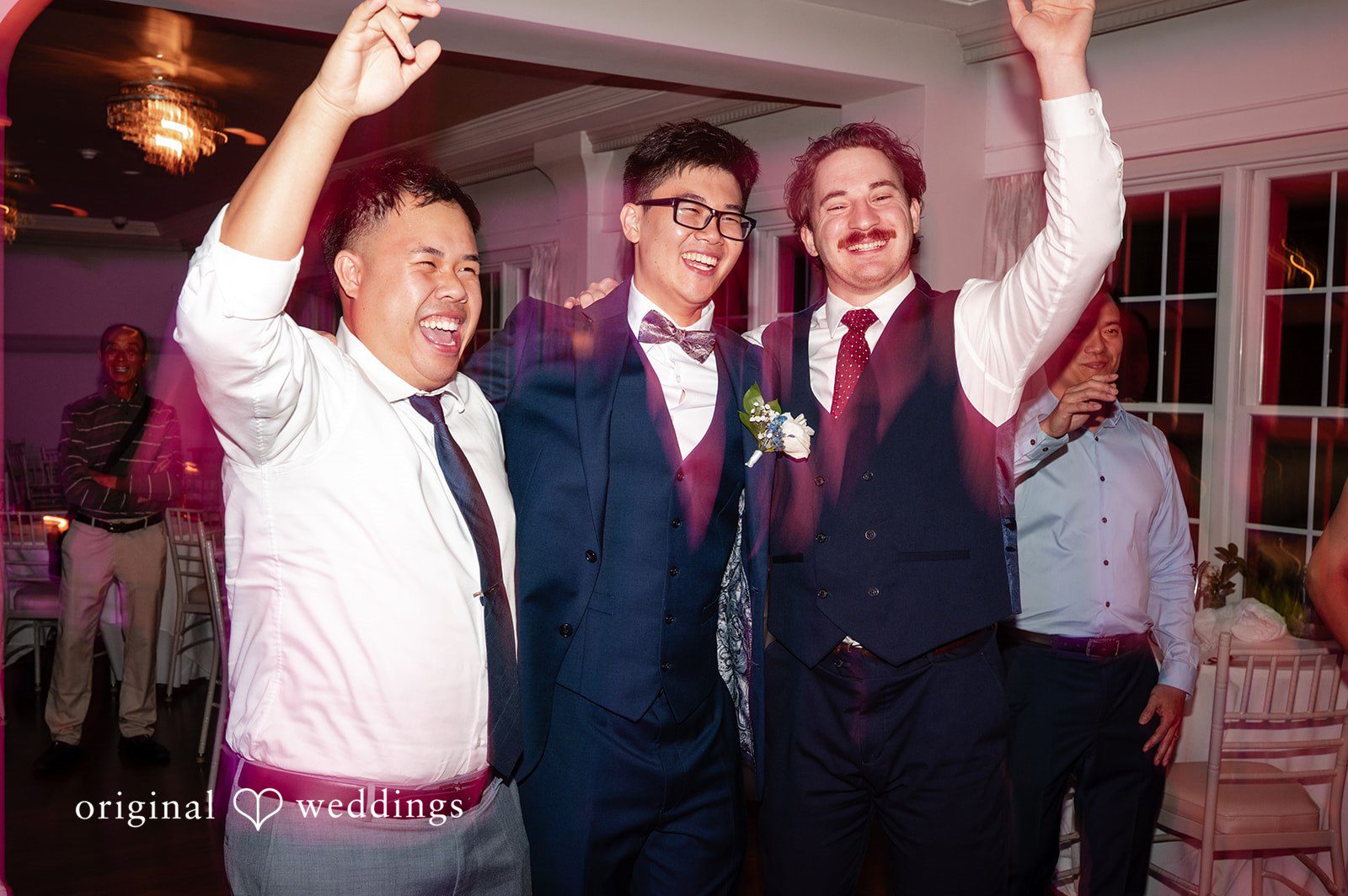 Groom and groomsmen standing together in matching dark suits.