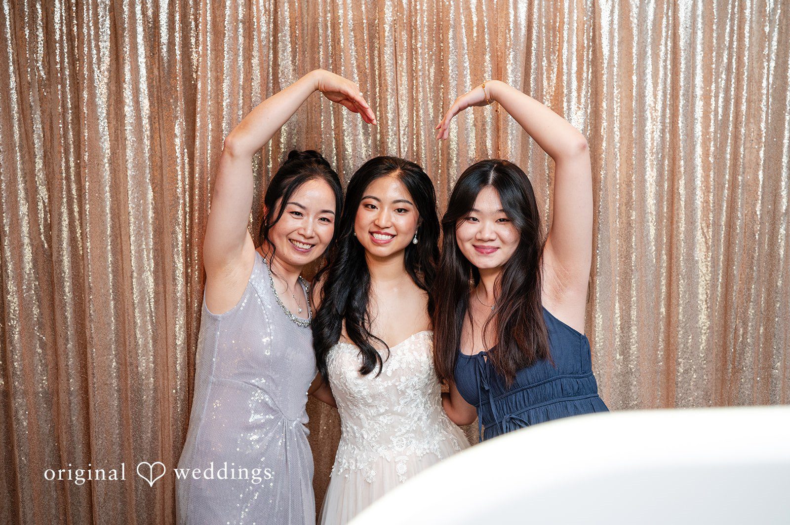 Bride and bridesmaids in light-colored gowns posing and cheering together.