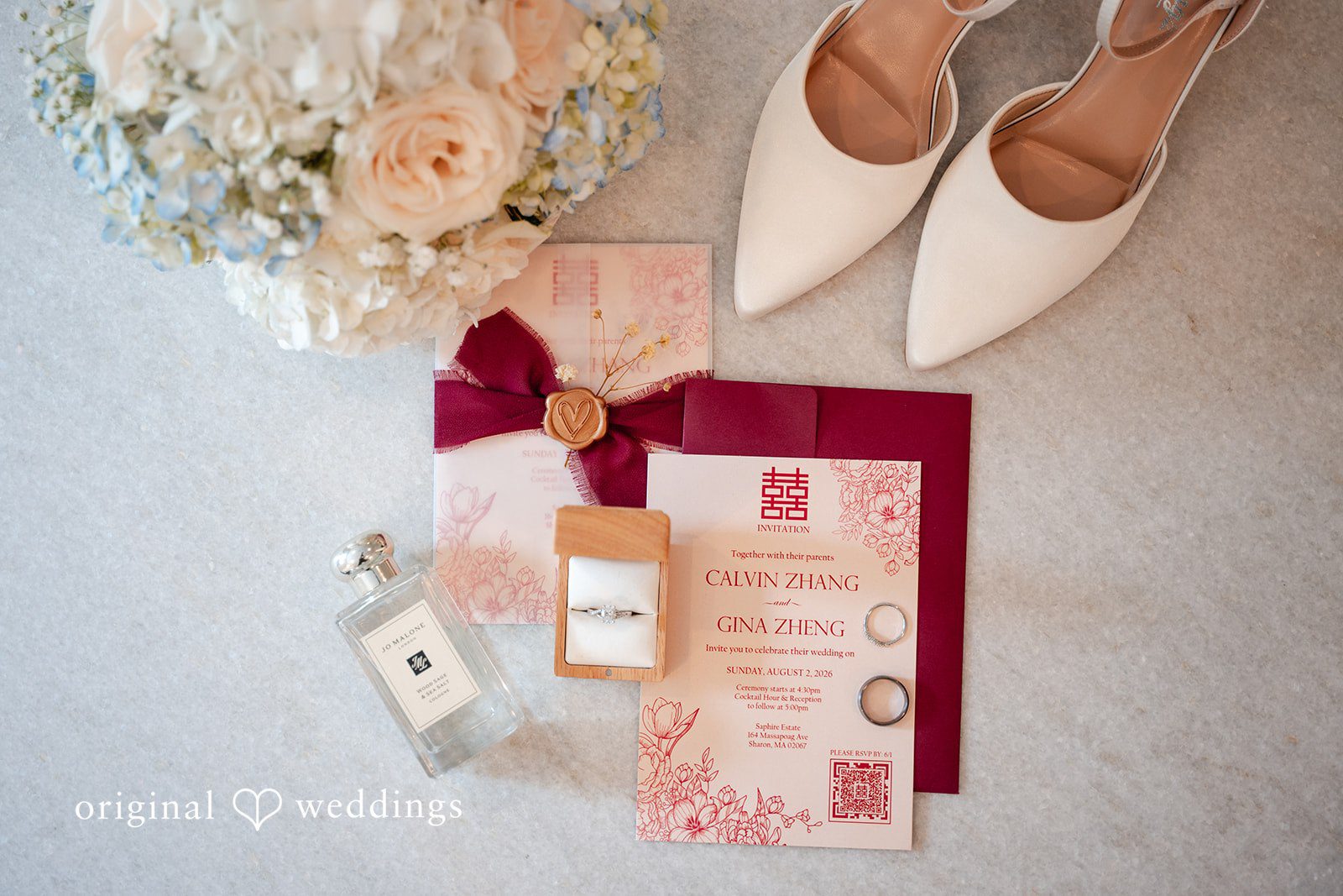 Bridal flat lay with invitations, elegant white shoes, and perfume.