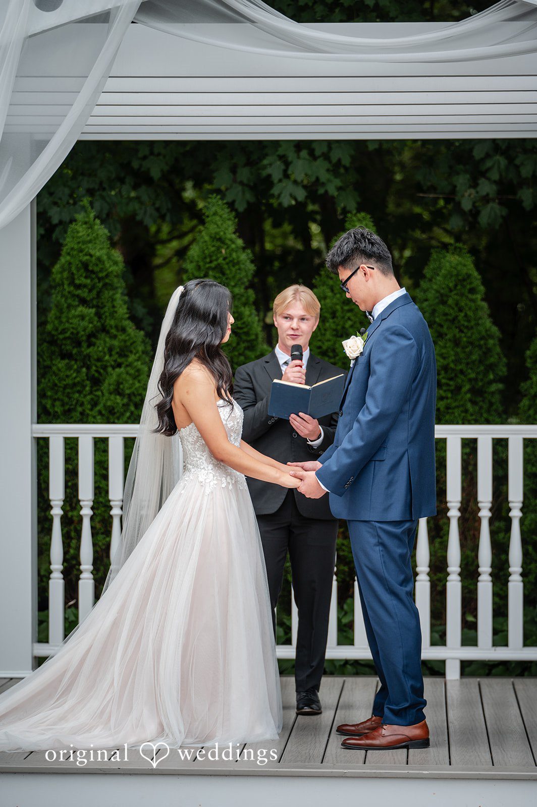 Bride and groom holding hands during an altar ceremony.