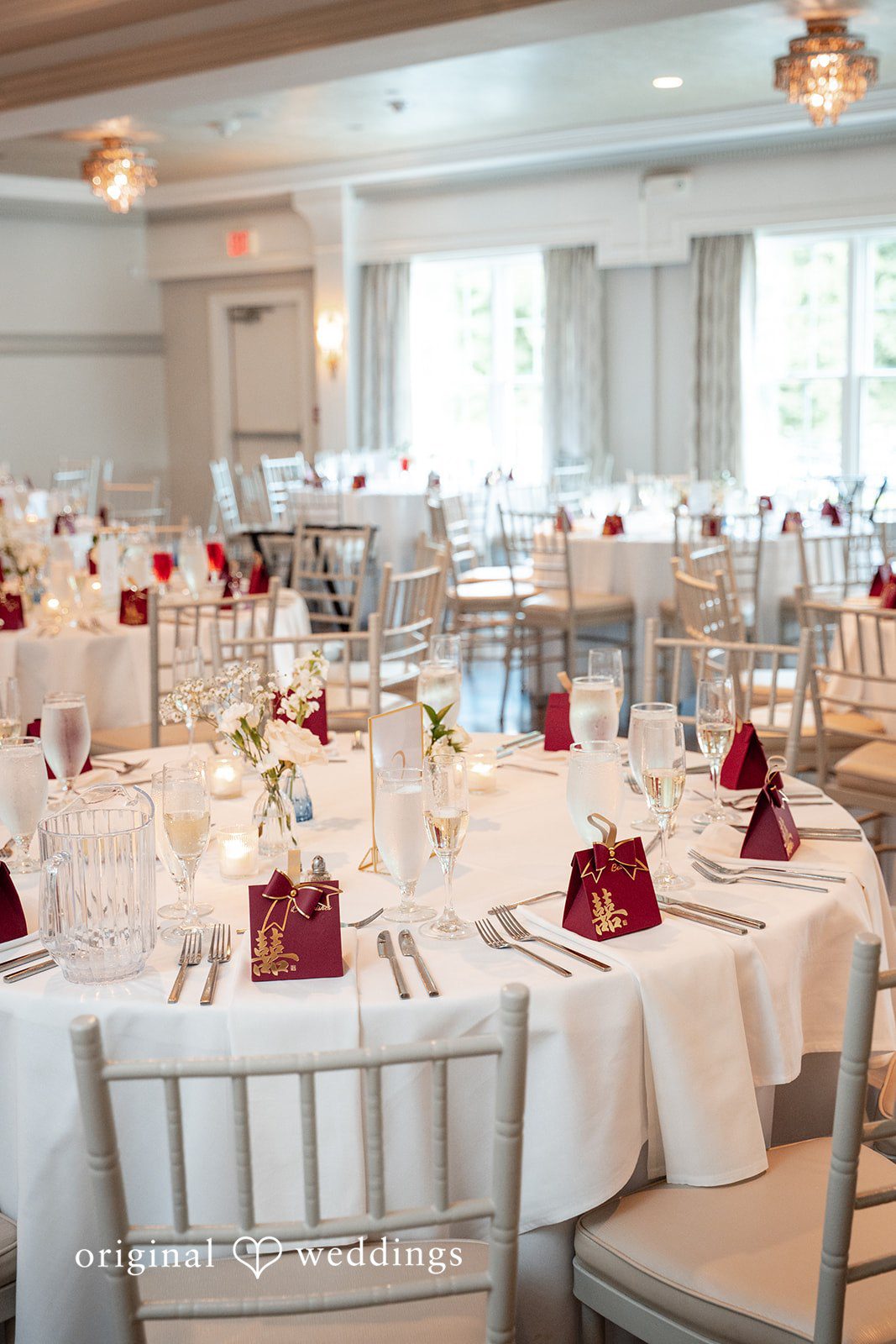 Banquet hall filled with decorated round tables for a reception.