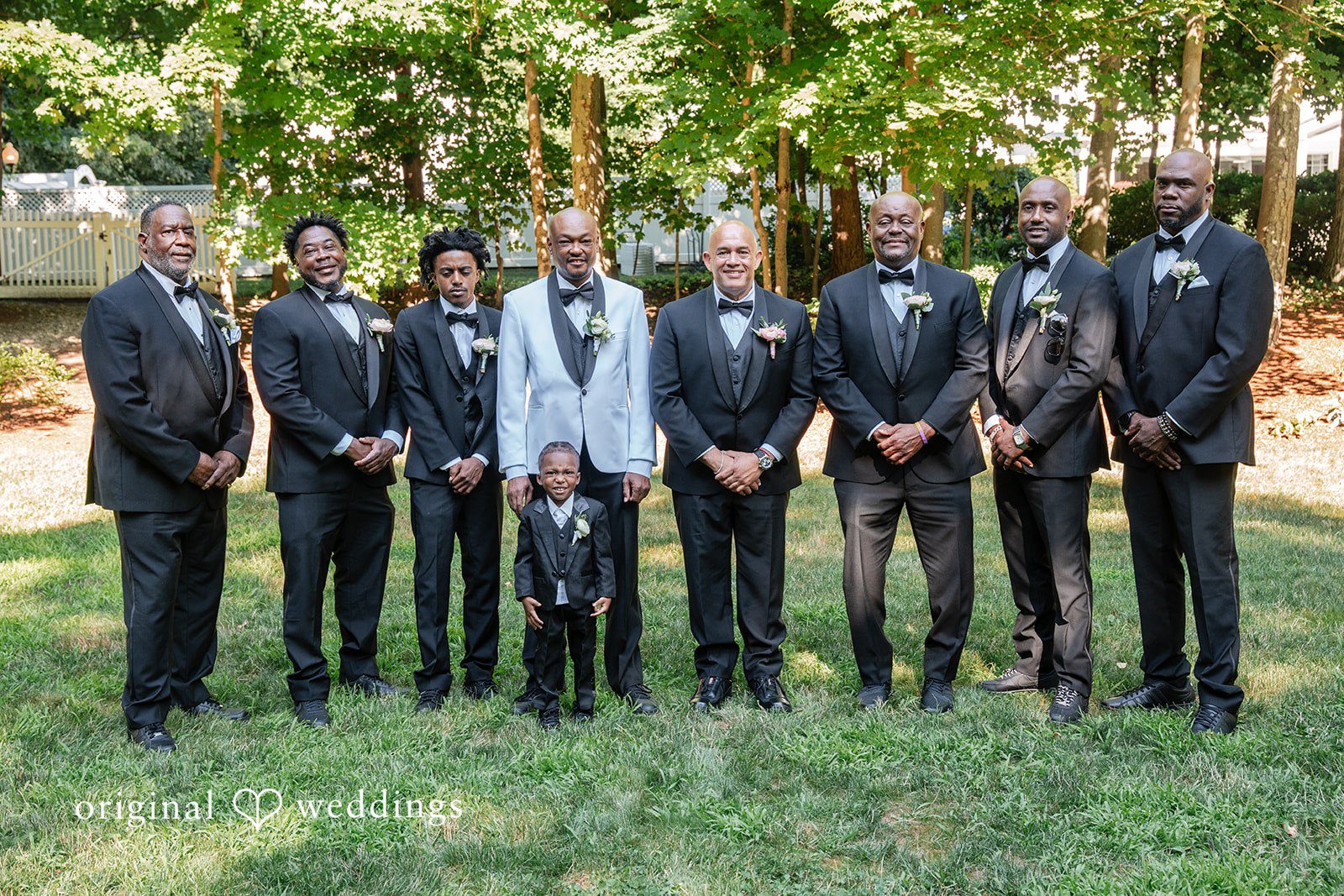 Melissa + Walter A groom standing with his groomsmen, all dressed in matching black suits.