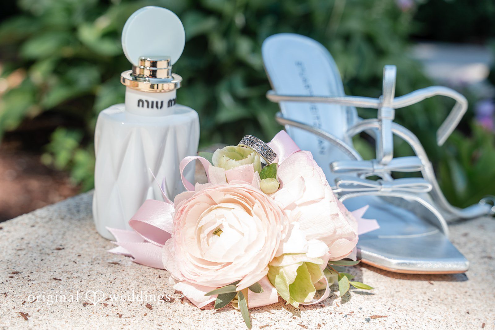 Melissa + Walter A pair of bridal shoes placed next to a bouquet of soft pink and peach flowers.