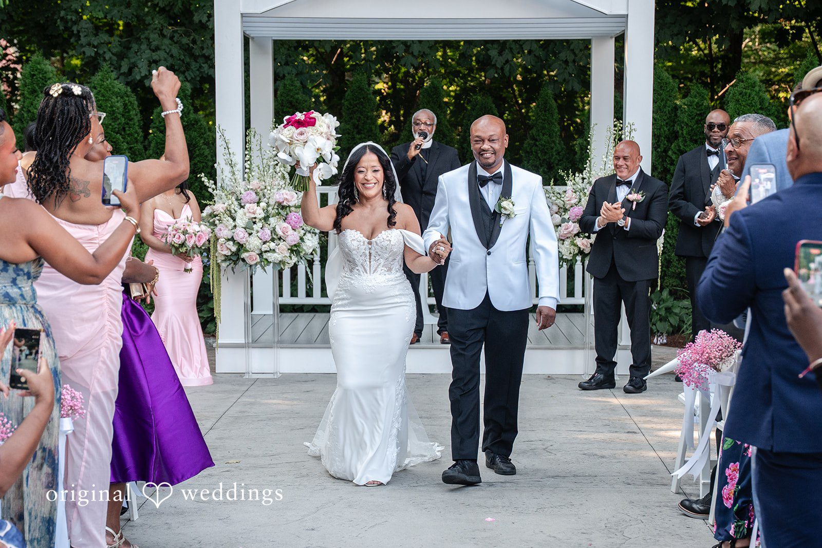 Melissa + Walter A newlywed couple walking down the aisle together as guests applaud.