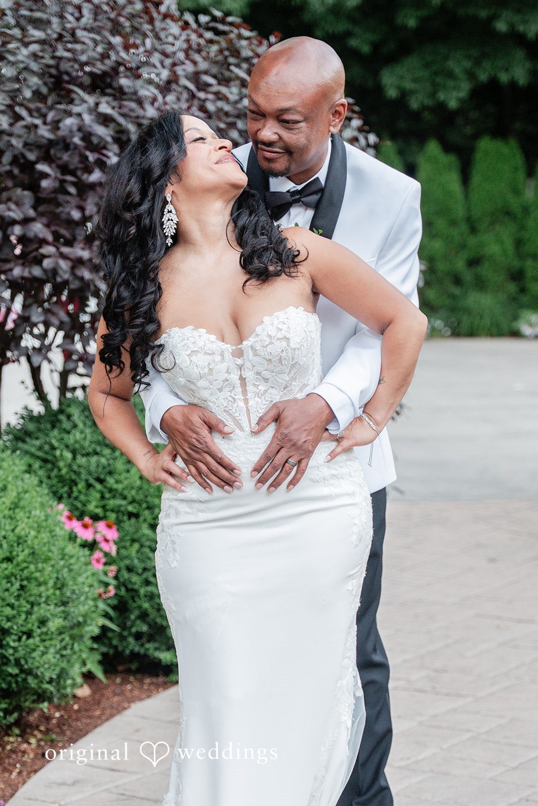 Melissa + Walter A groom lifting and holding his bride close as they pose together after the ceremony.