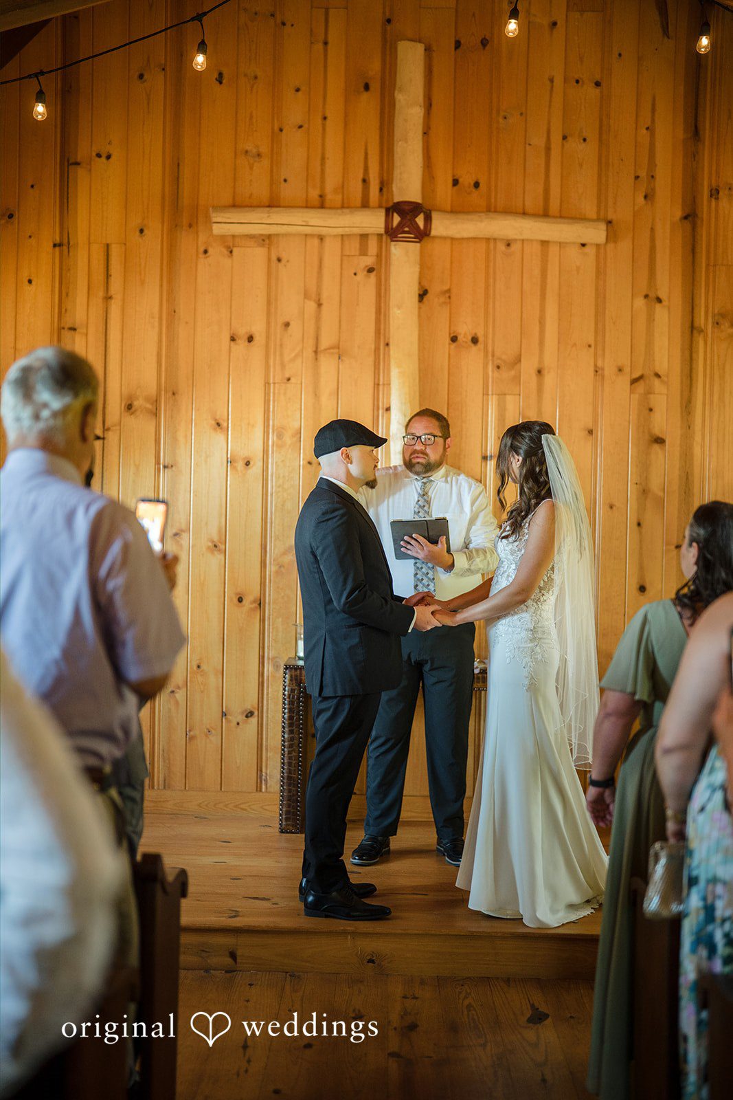 Jade + Nicholas A wedding ceremony taking place before a wooden wall.
