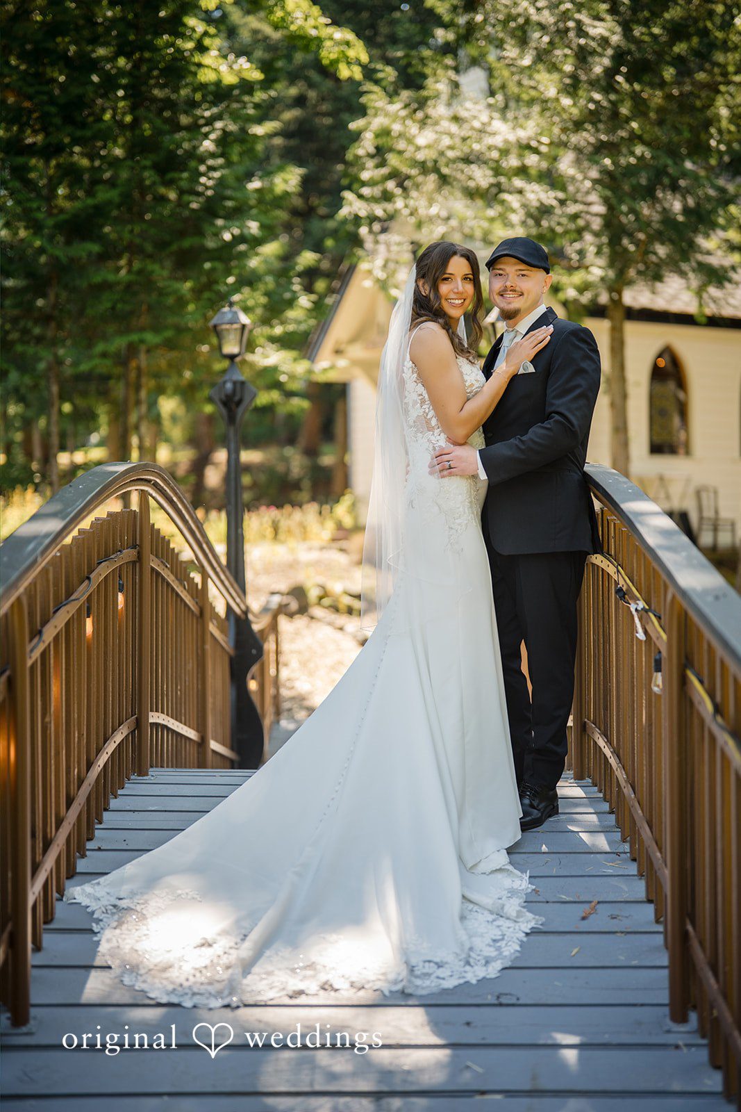Jade + Nicholas A bride and groom embracing on a wooden bridge path.
