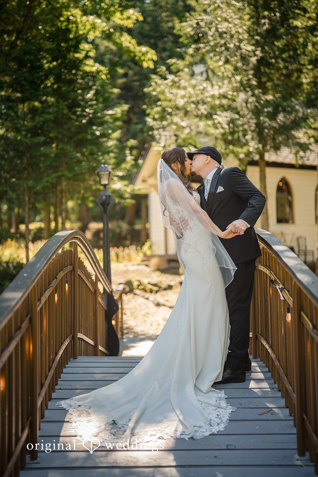Jade + Nicholas A bride and groom holding hands while walking across a wooden bridge.