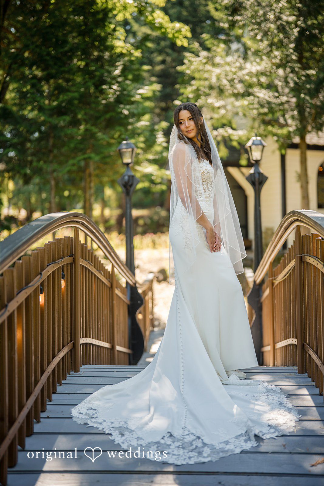 Jade + Nicholas A bride standing on an elevated wooden walkway while looking down.