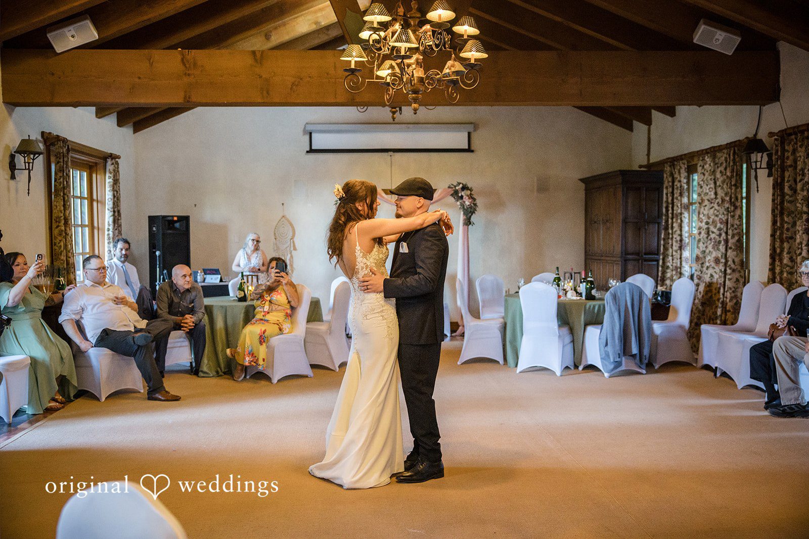 Jade + Nicholas A bride and groom dancing together in the center of a reception hall room.