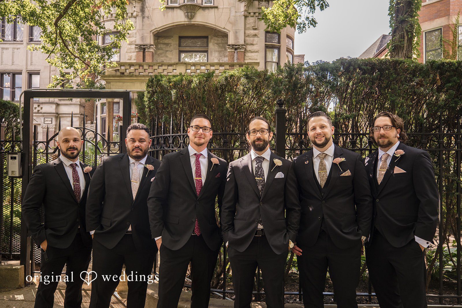 Kimberly + David Groom and groomsmen in dark formal suits posing for a portrait.