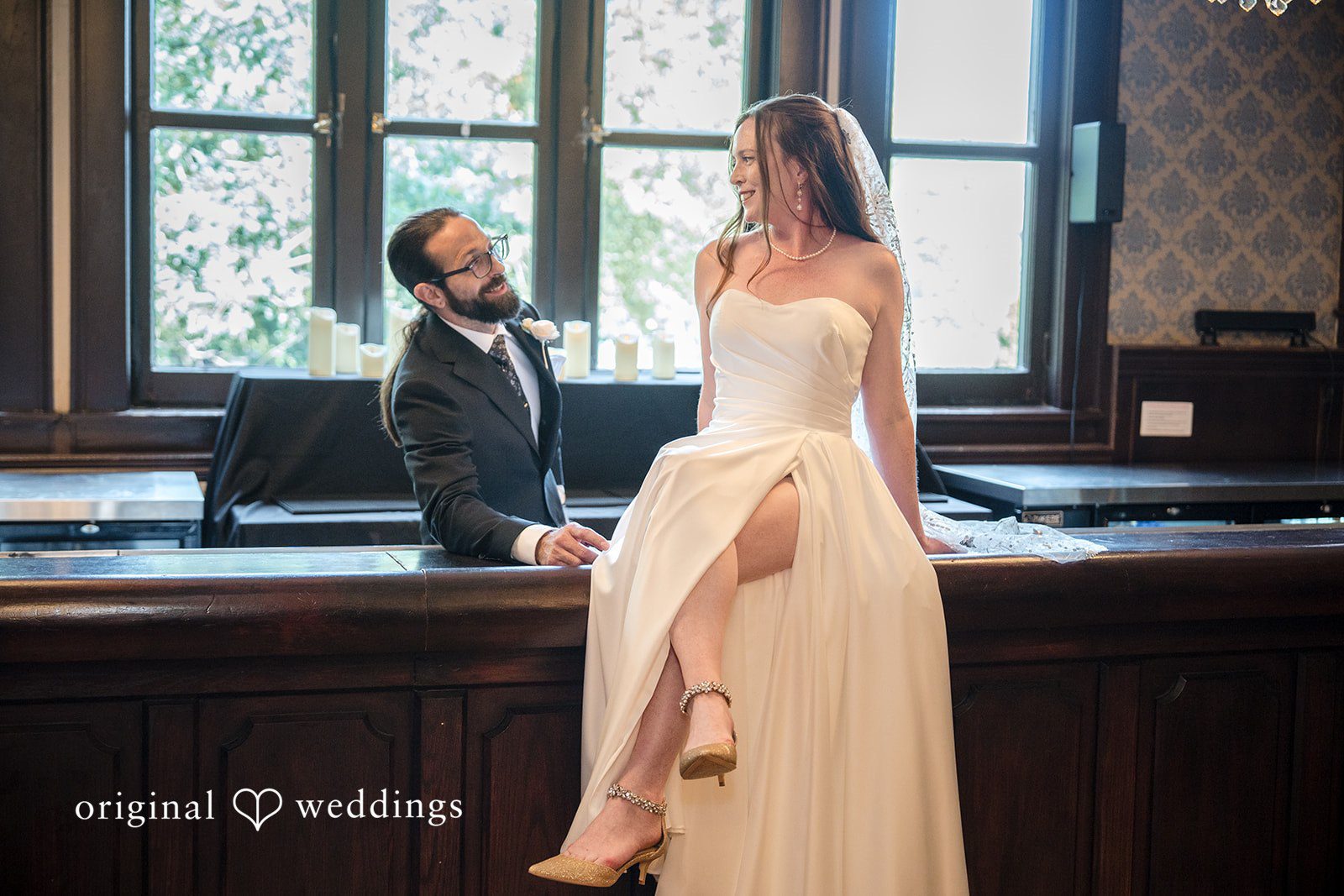 Kimberly + David Bride and groom sharing a quiet moment sitting together on a dark wooden bar.