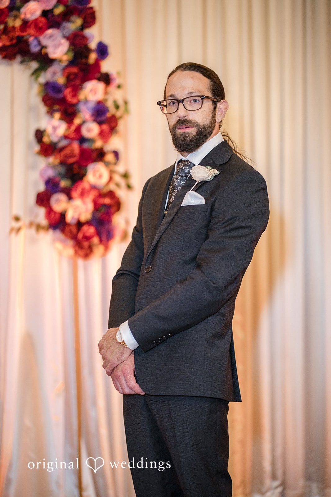 Kimberly + David Groom in a classic dark suit smiling for a portrait.