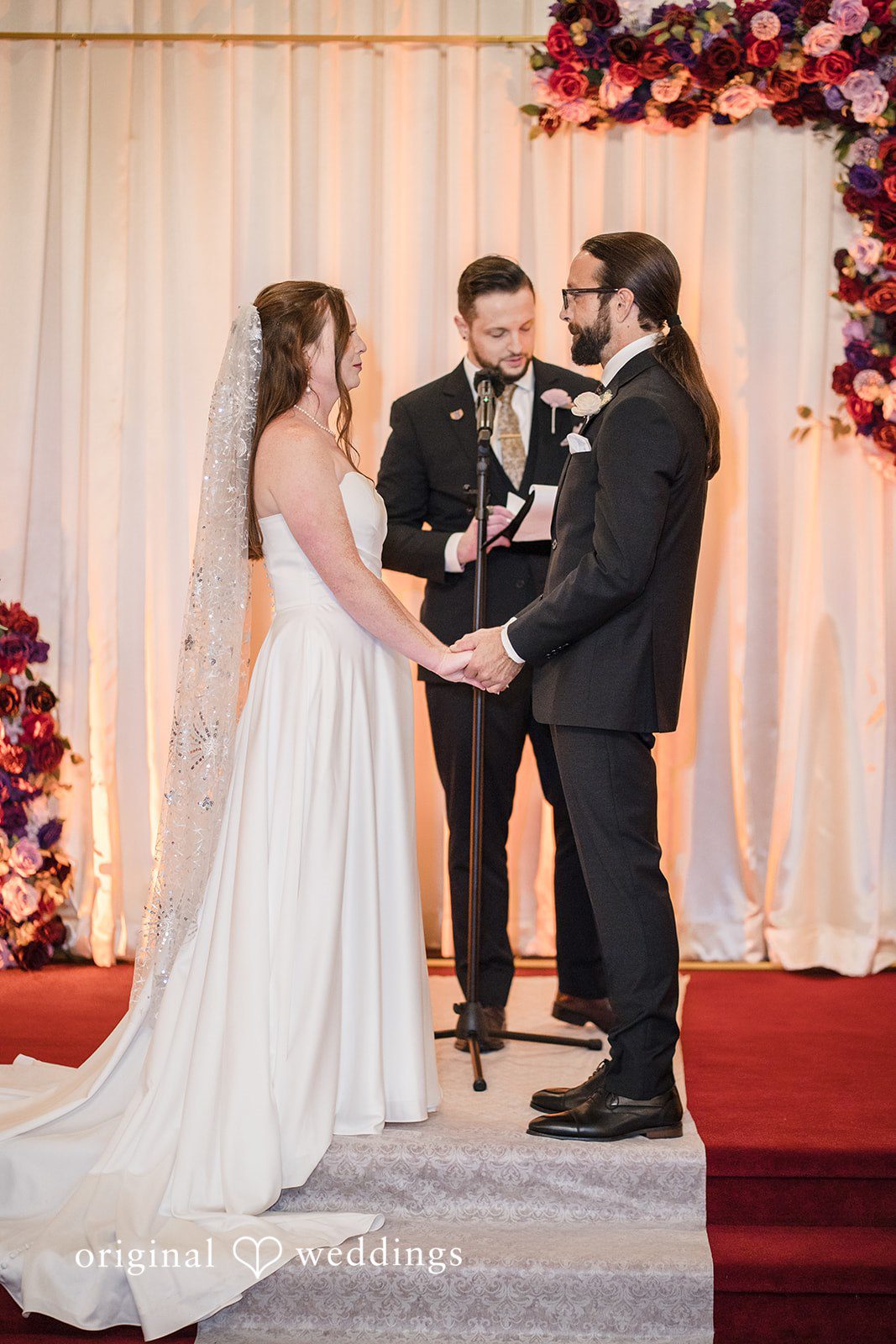 Kimberly + David Bride and groom holding hands during their wedding ceremony.