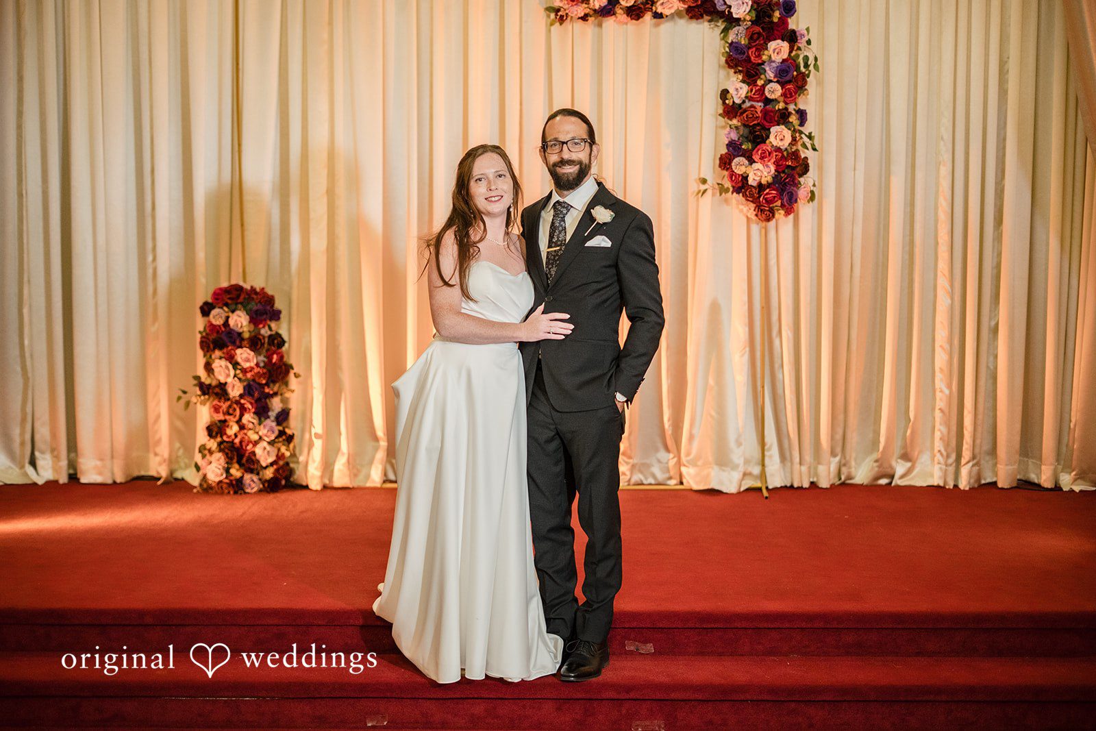 Kimberly + David Bride and groom standing together on a red carpet.