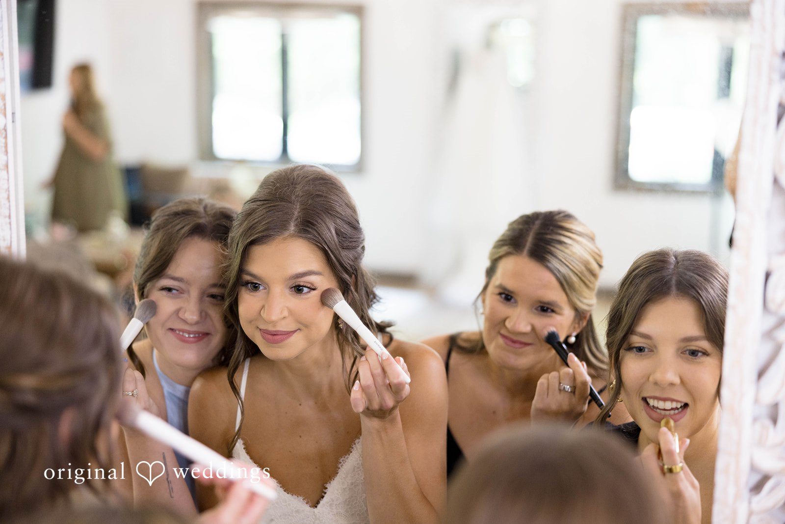 A group of bridesmaids share a joyful, candid moment while getting ready.