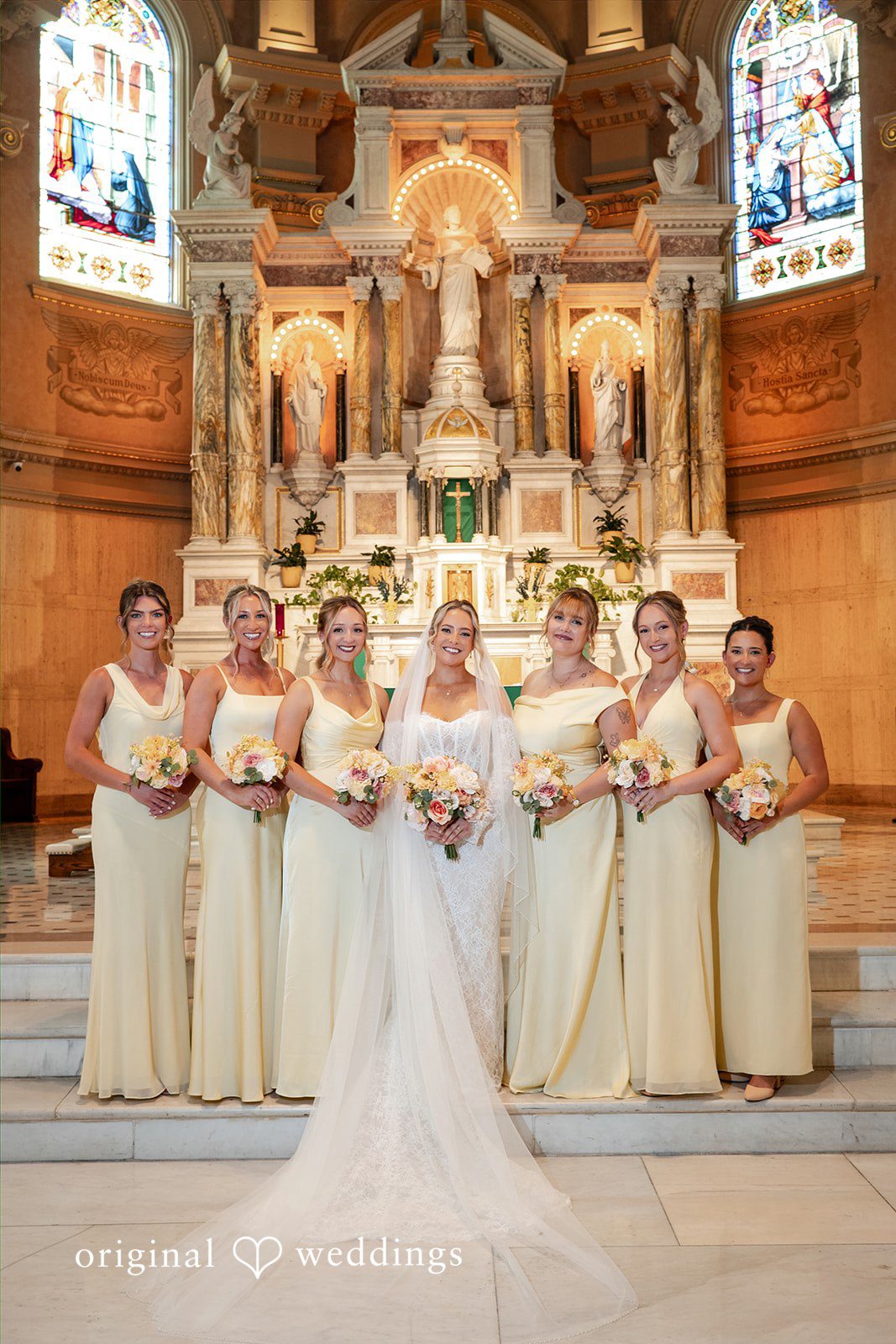 A bridal party stands assembled near a grand church altar.