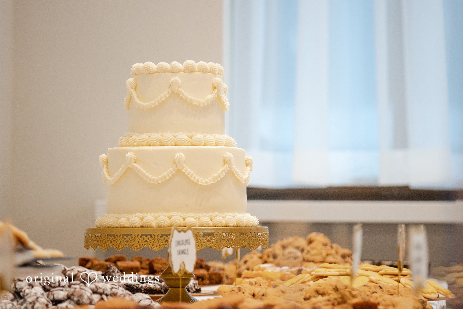 A towering, intricate gold wedding cake stands on display.