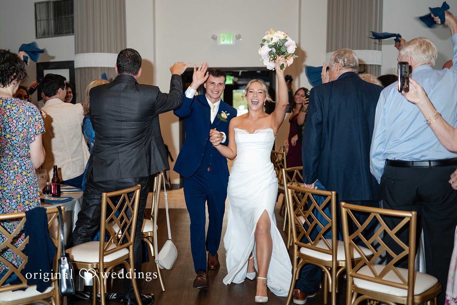 Wedding guests raise their hands and dance during a lively reception party.