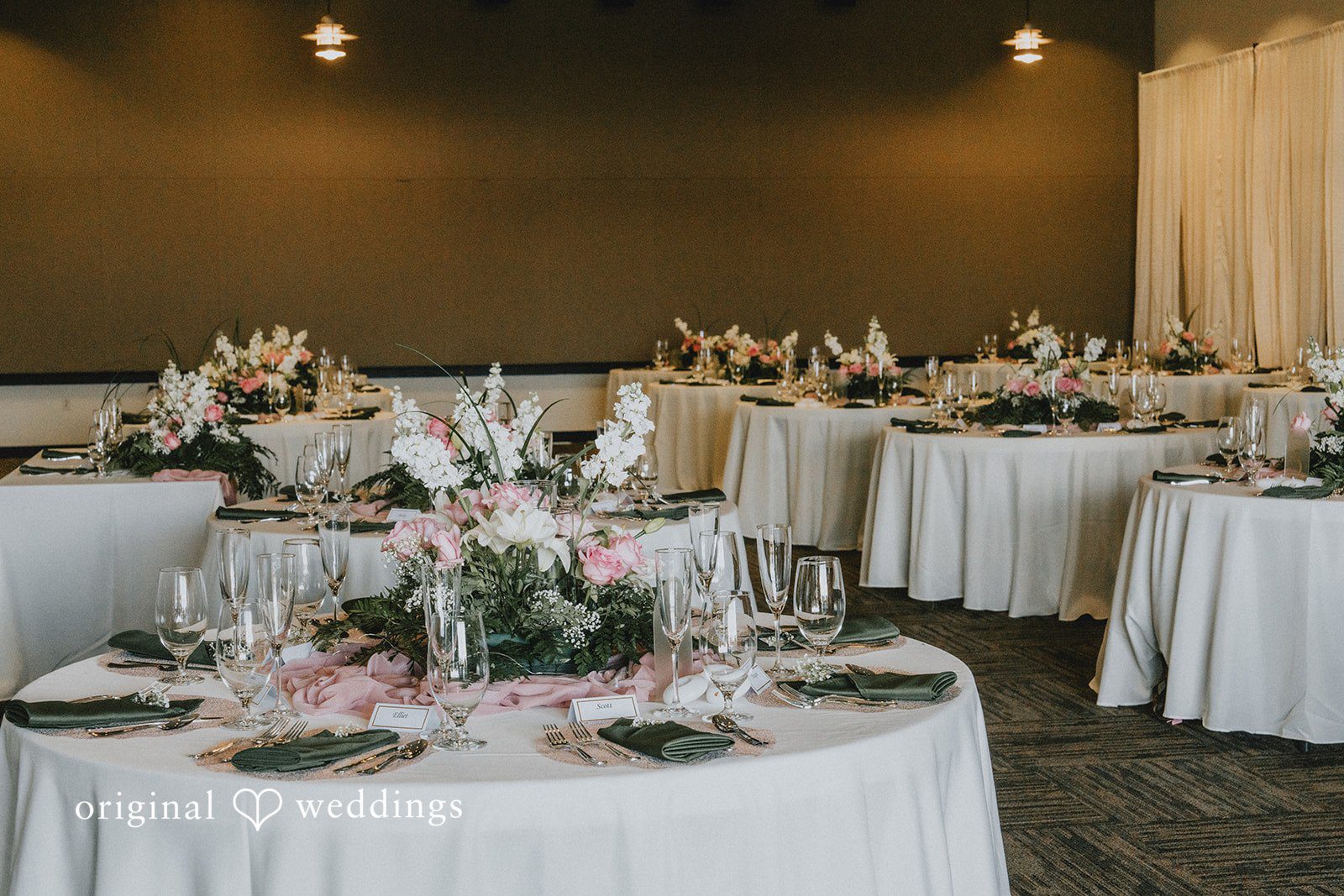 Ashley + Dylan A beautifully decorated round wedding reception table with white linens and floral centerpieces.