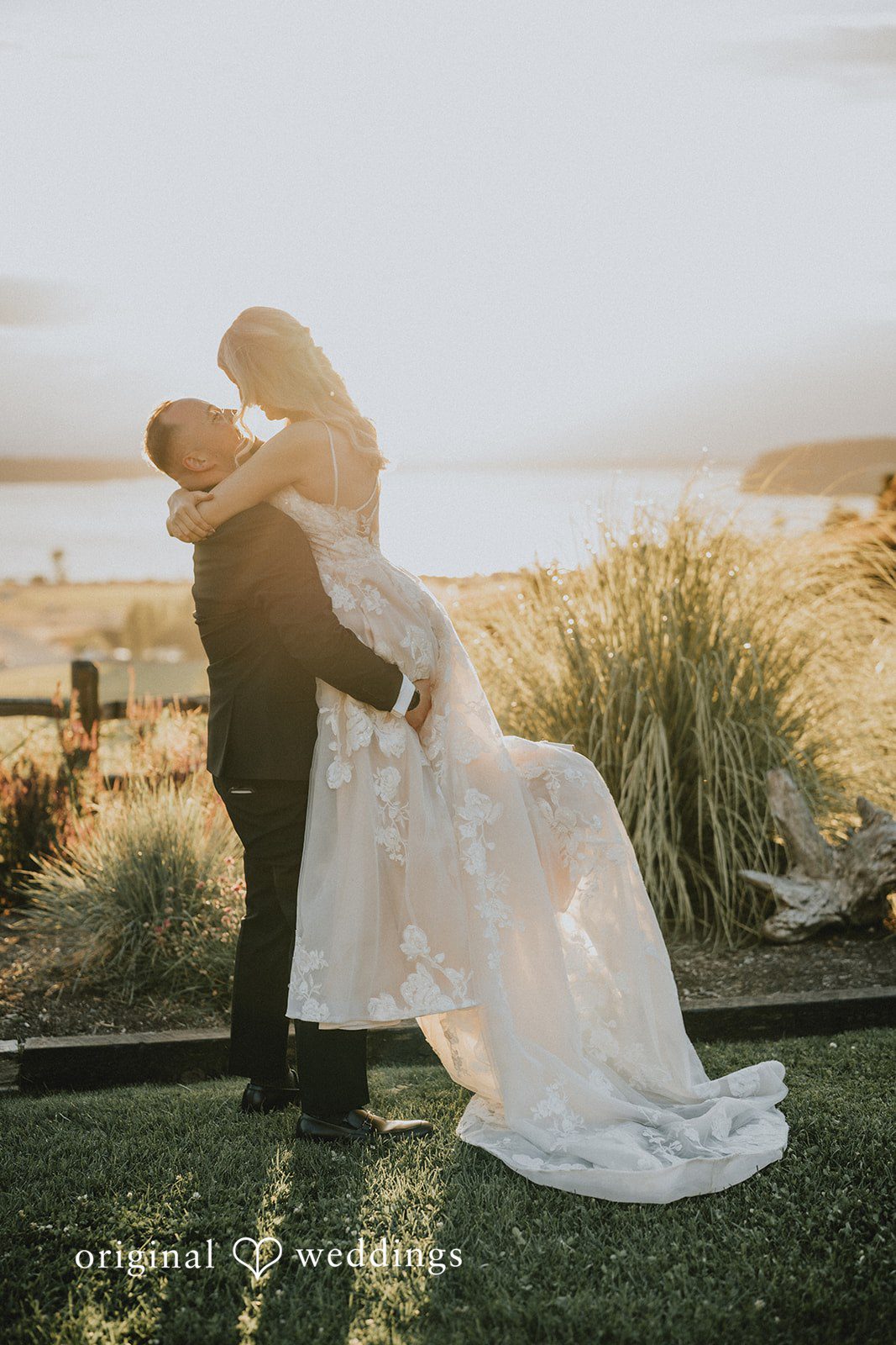 Ashley + Dylan A groom dipping his bride backward in a dramatic embrace in an open field.