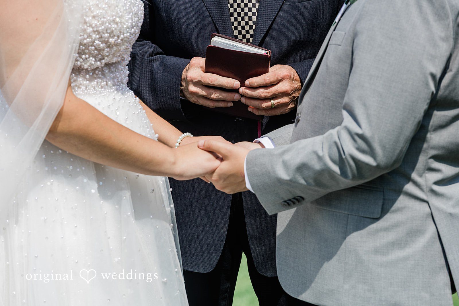 A close-up view of two people exchanging rings during a formal ceremony.