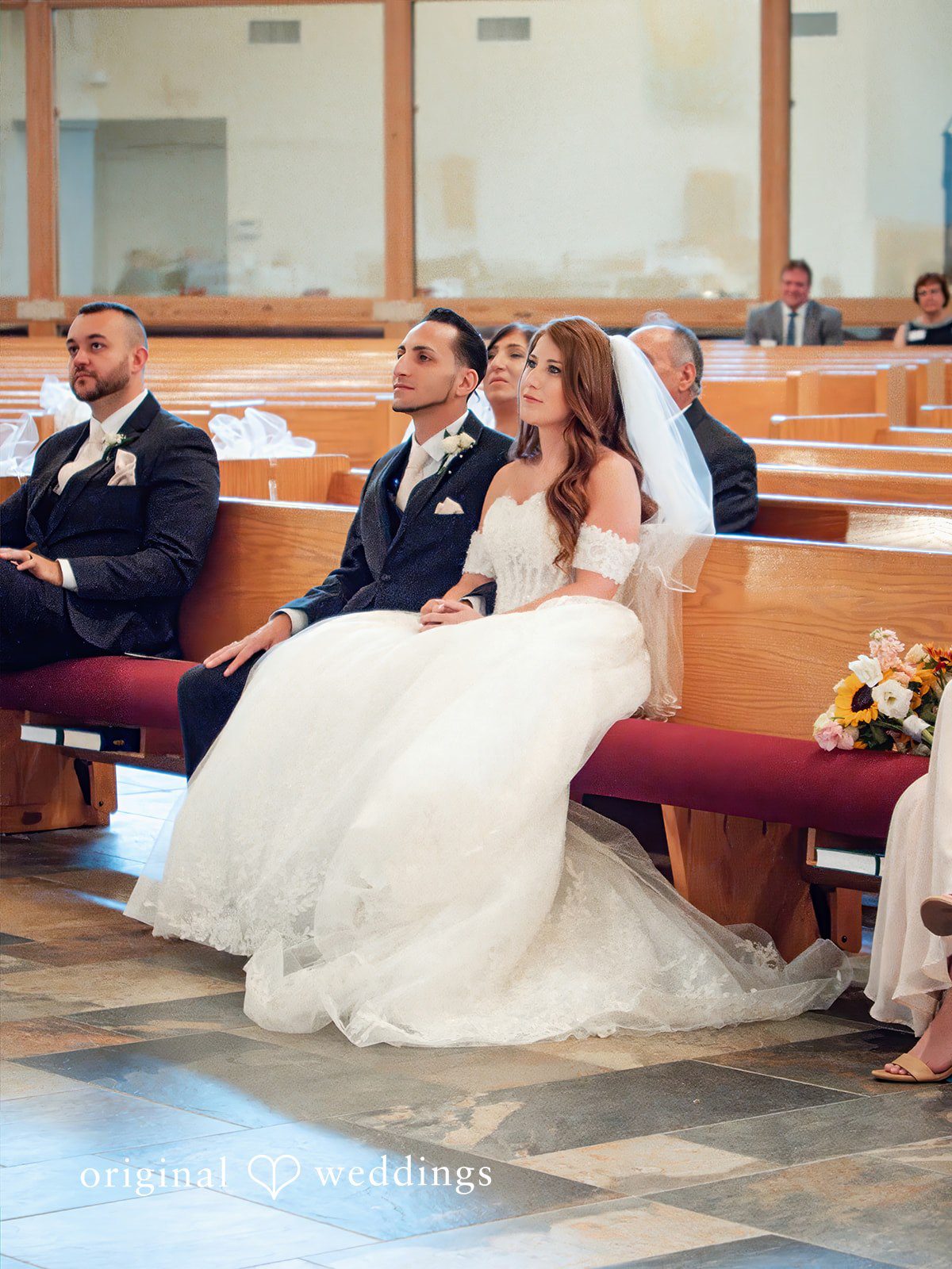 July 11, 2026 – Vincenzo & Kristin – (ID-4669) REVISED 9.6 A bride and groom sitting together in church pews during their wedding service.