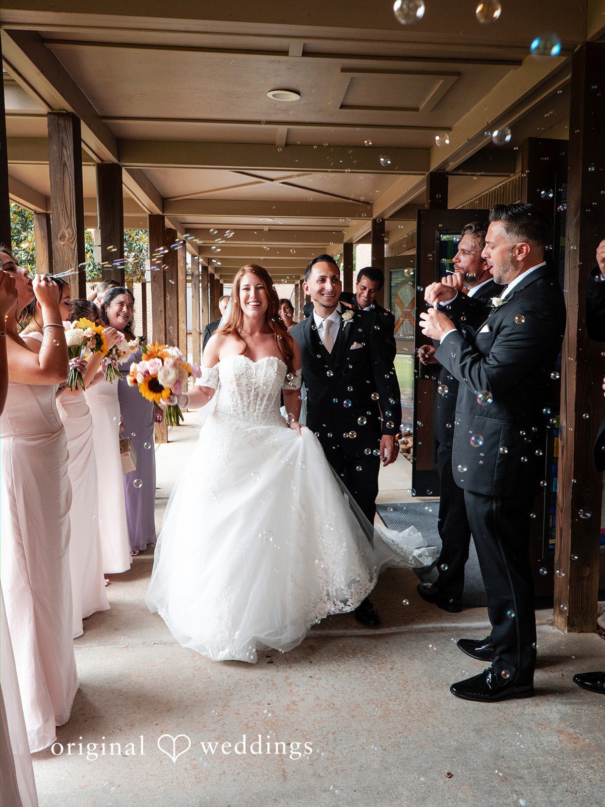 Vincenzo + Kristin A bride and groom walking together at a rustic wedding venue.