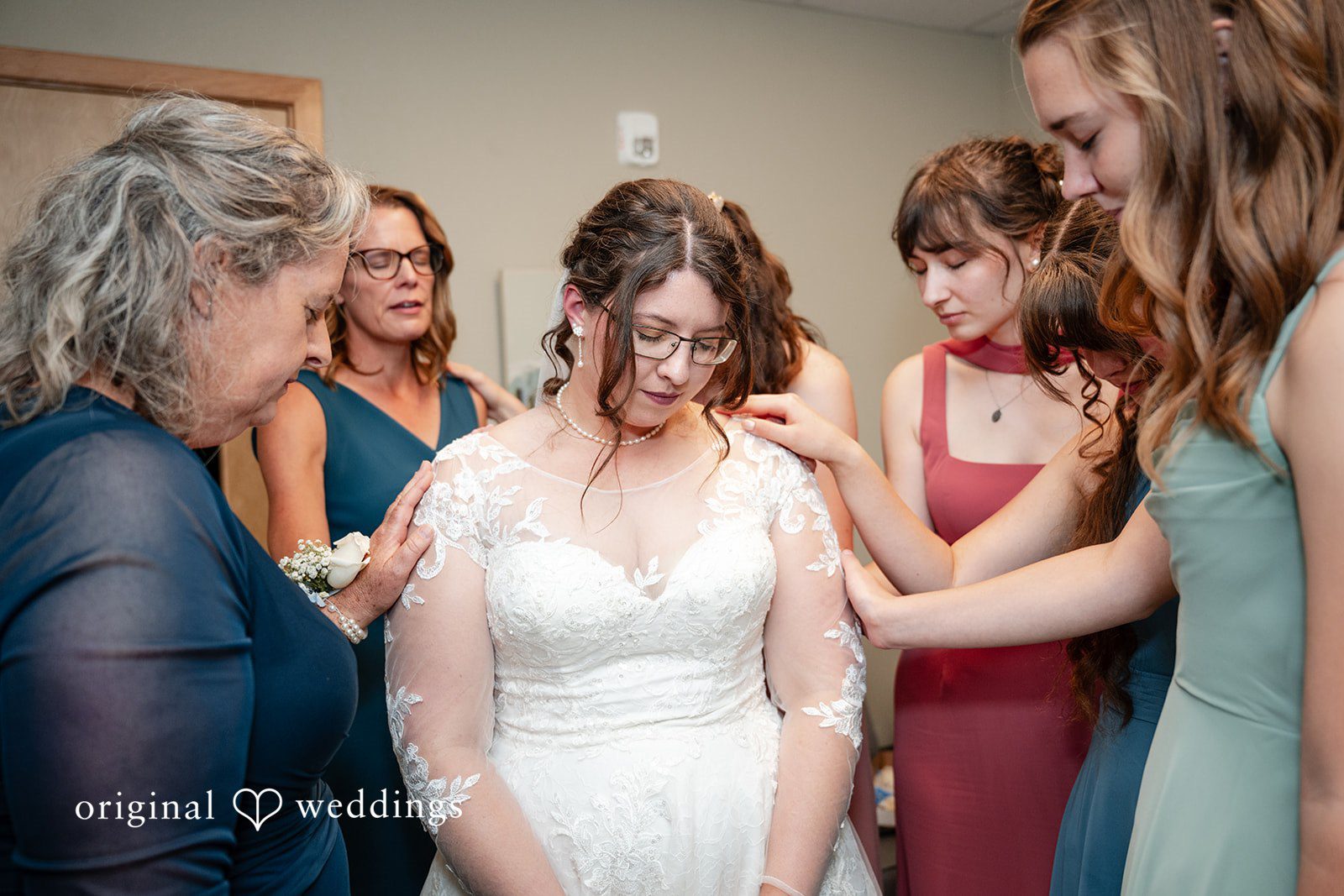 Emma + Aidan A bride adjusting her gown while surrounded by her bridesmaids.