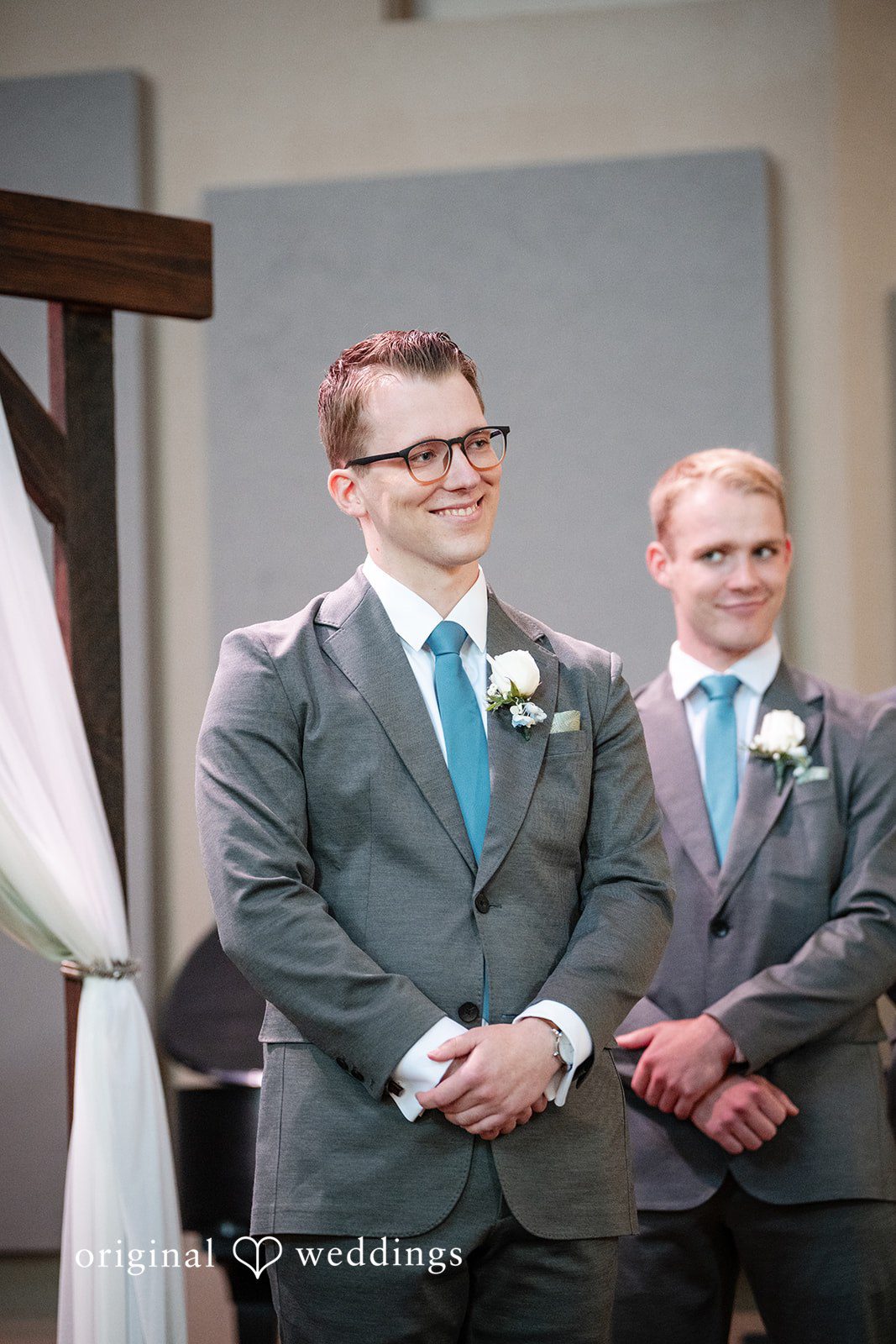 Emma + Aidan Groom and groomsmen in grey suits and blue ties smiling together.